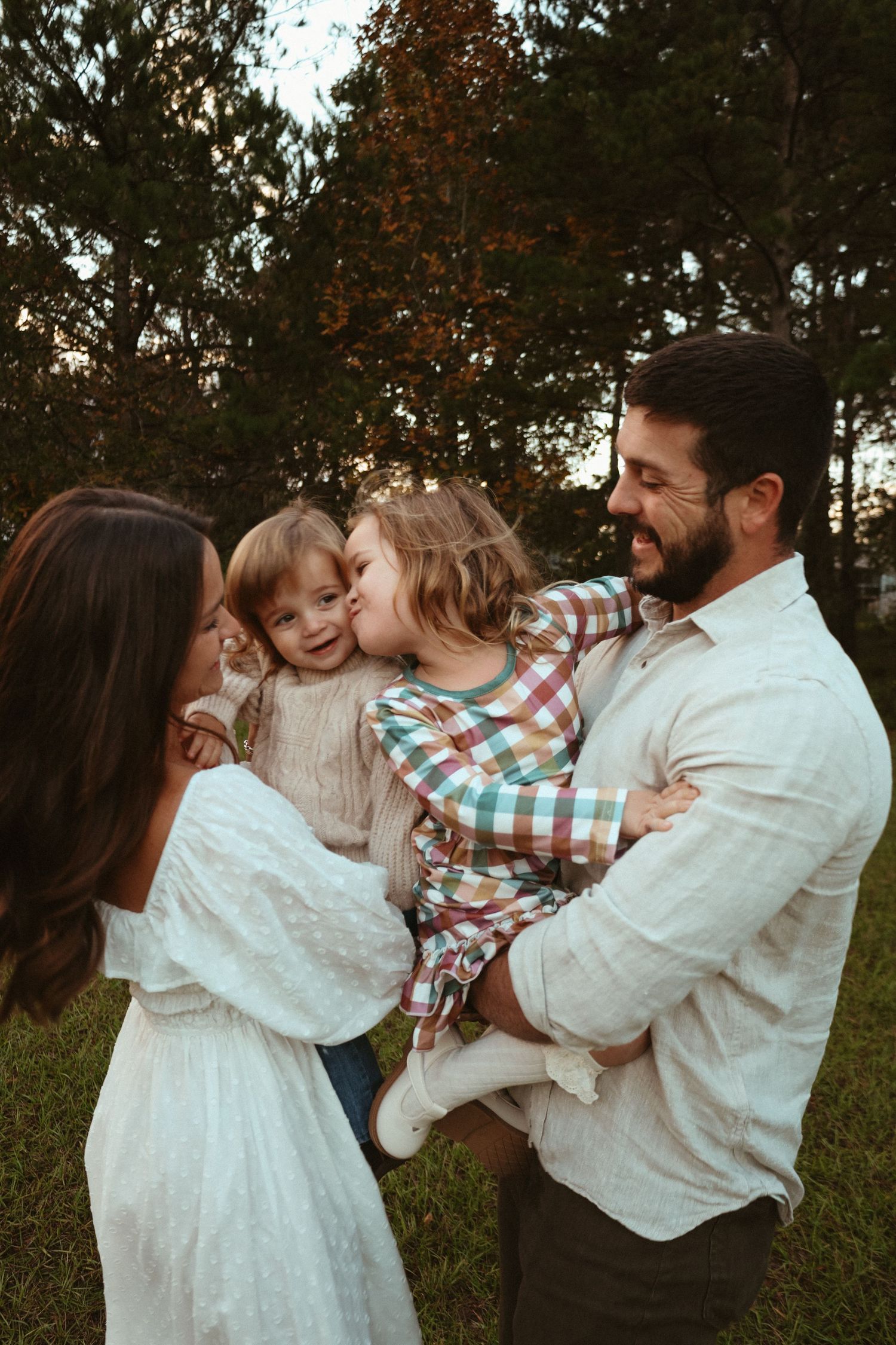A family shares tender moments together outdoors in a series of candid photos showing hugs and affection.