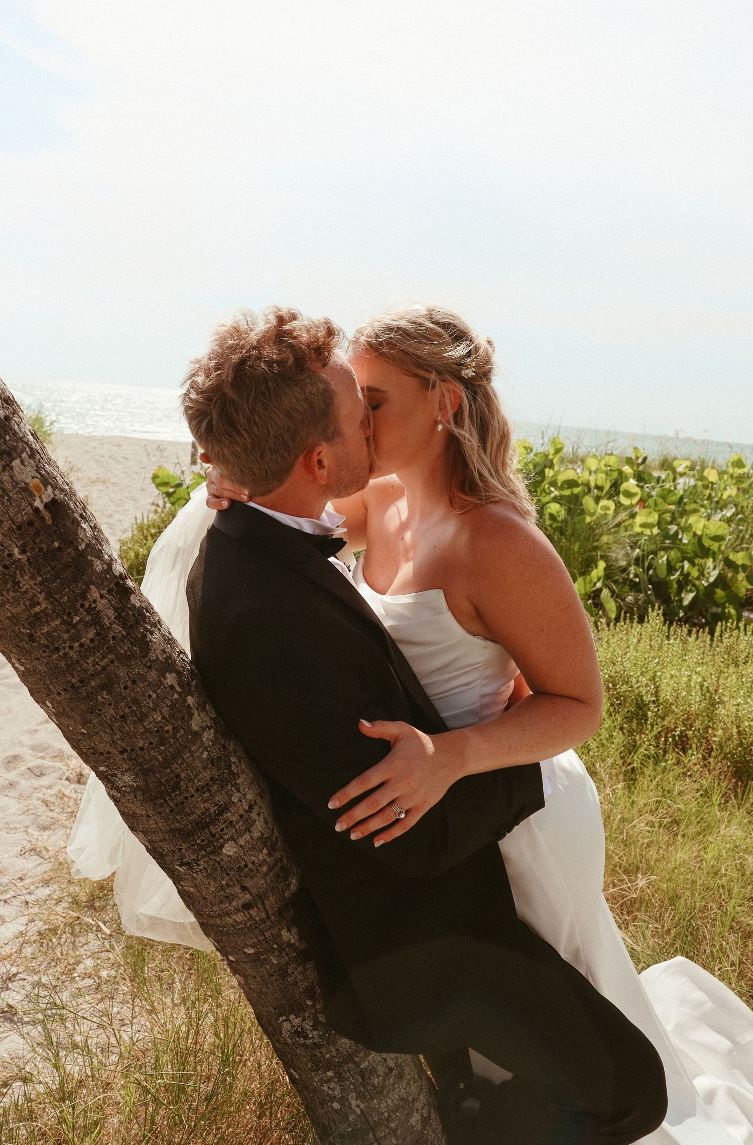 A romantic wedding couple sharing intimate kisses outdoors in sequence with a rustic tree setting.