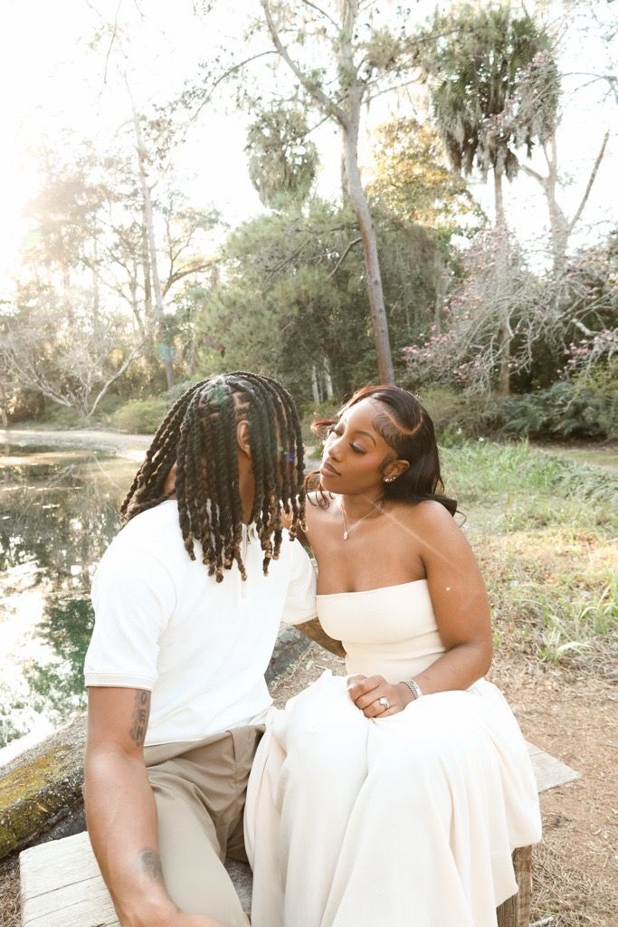 Romantic couple in white outfits share intimate moments outdoors during a golden hour photoshoot in nature.