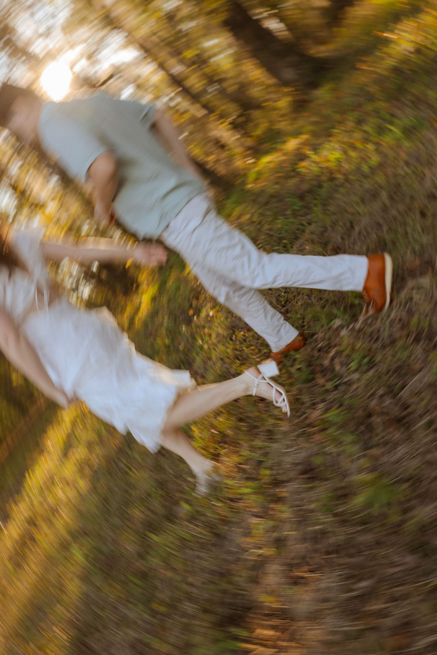 Motion blurred sequence of a person in white clothing falling or spinning on autumn grass and leaves.