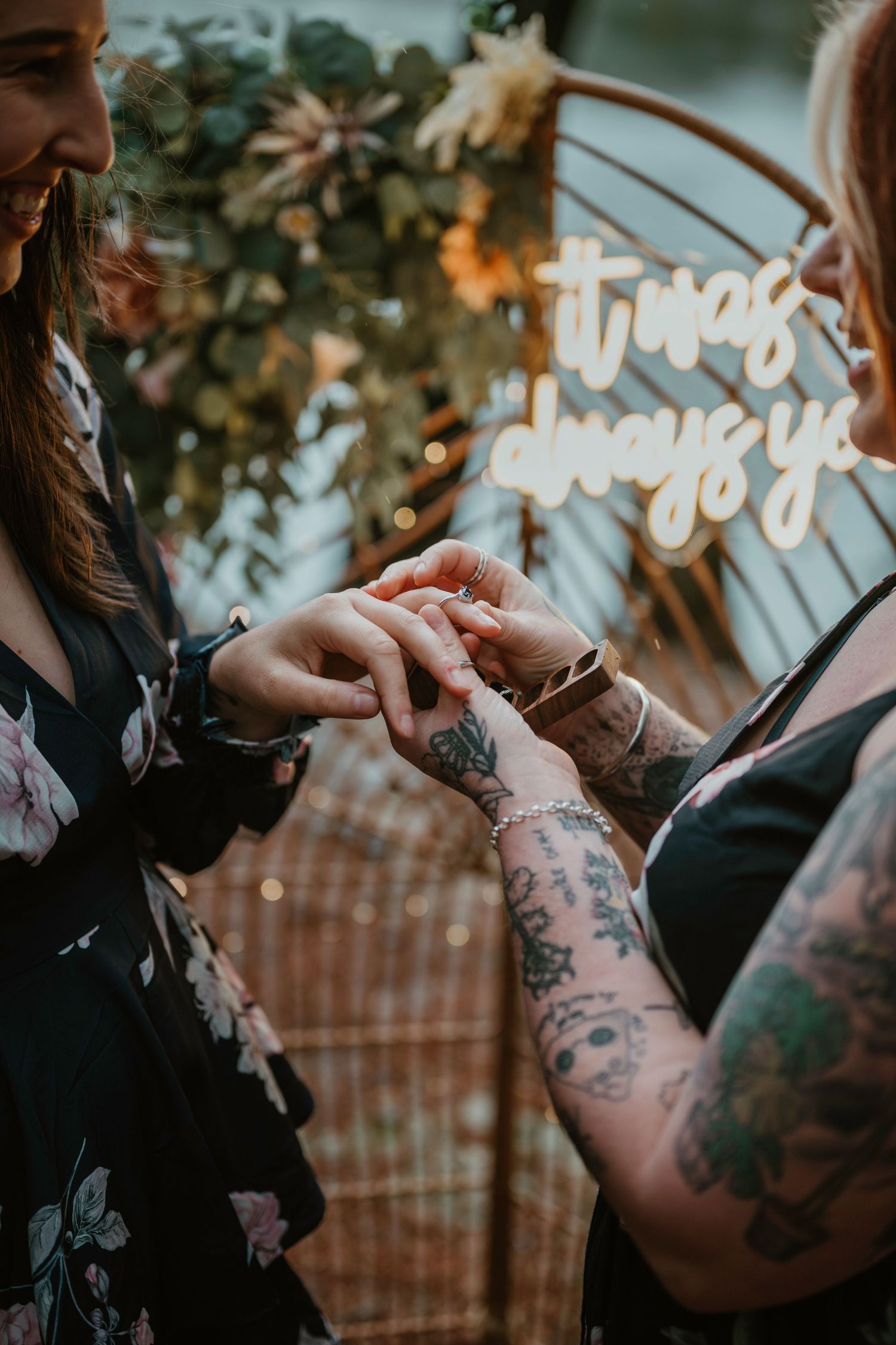 An intimate moment captured with glowing lights and visible tattoos.