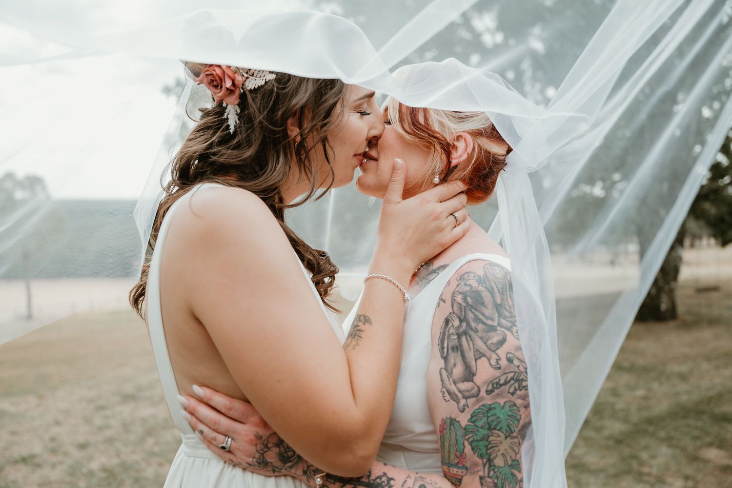 Intimate wedding moment captured outdoors with flowing veil.