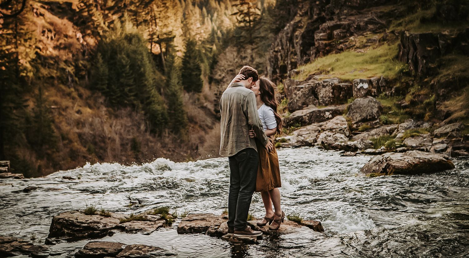 Romantic wedding couple silhouetted against dramatic canyon landscape at sunset.