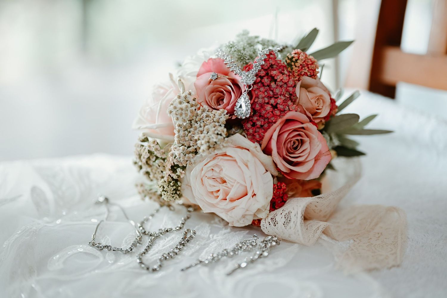 Elegant arrangement of pink and blush roses with baby's breath on a light surface.