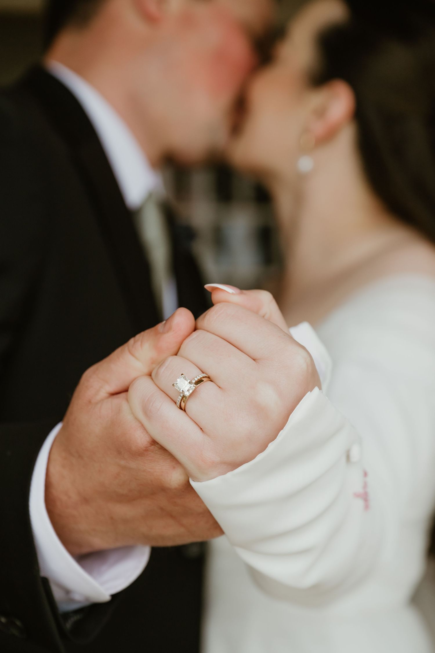 Close-up series showing a diamond engagement ring on a hand against dark background with elegant wedding attire.