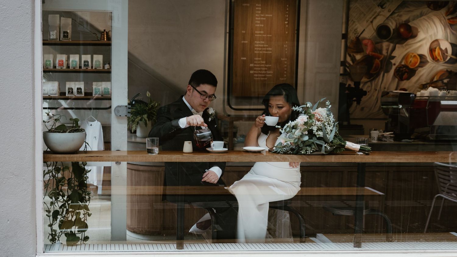 A cozy coffee shop interior with dark wood paneling, counter seating, and warm lighting creates an inviting atmosphere.