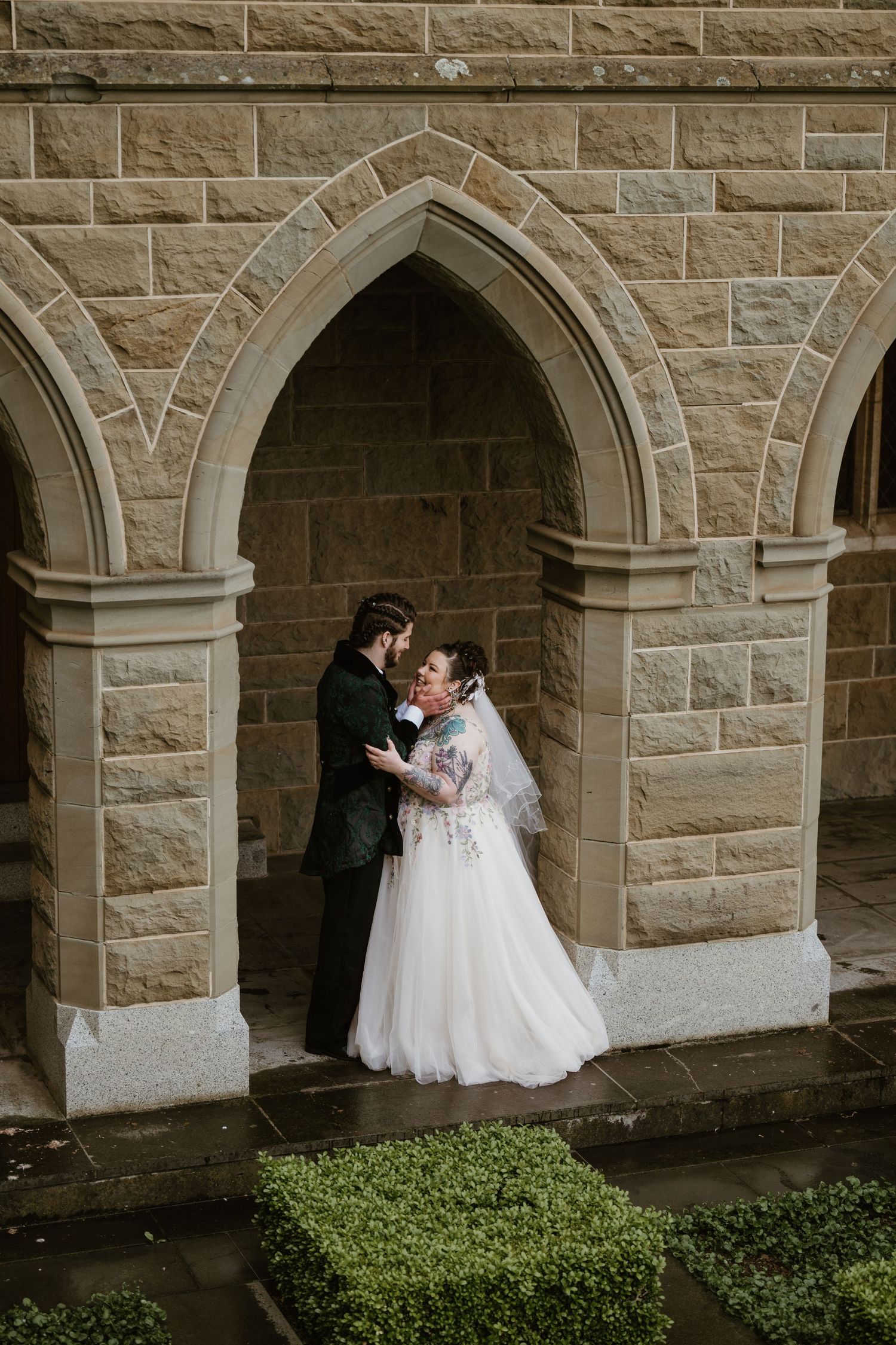 A romantic wedding moment captured in a series of three photos against a stone archway and garden wall.