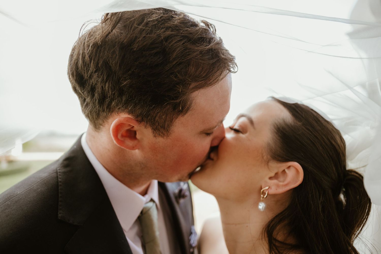 A romantic wedding couple shares an intimate kiss during their special day.