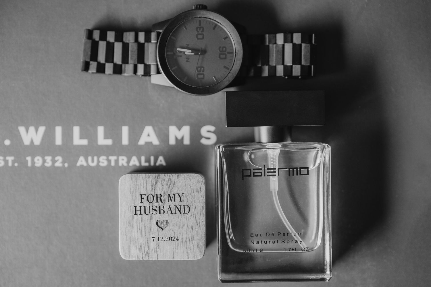 Wedding accessories including watches and fragrances arranged in monochrome.