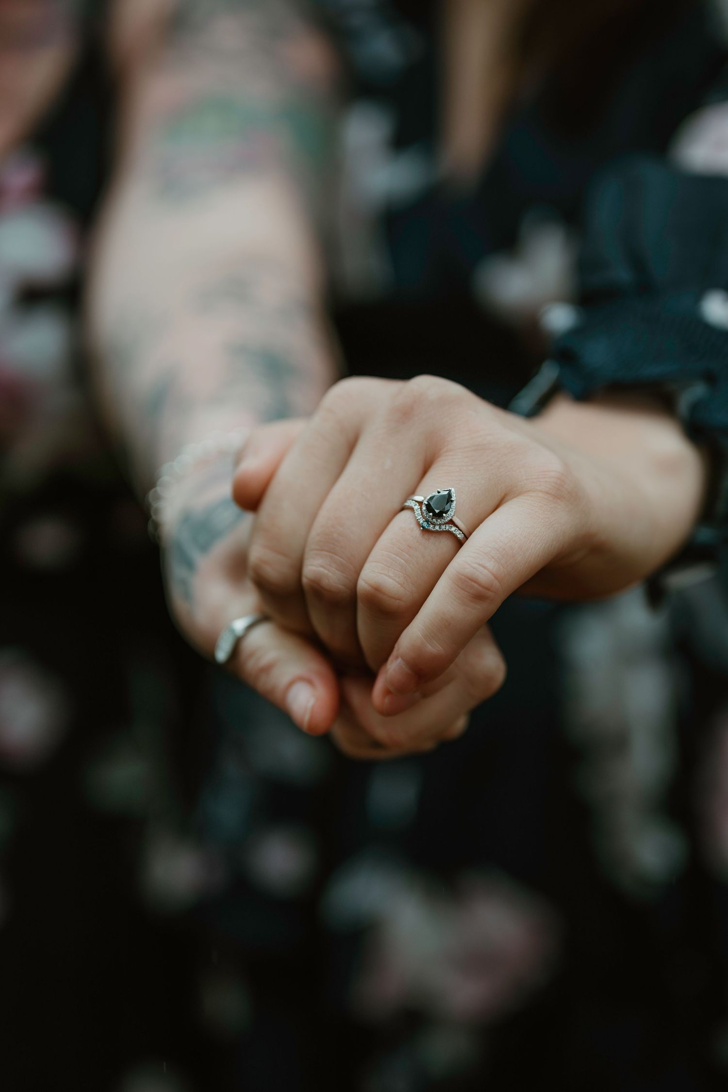 Close-up of hands displaying an engagement ring with delicate detailing.