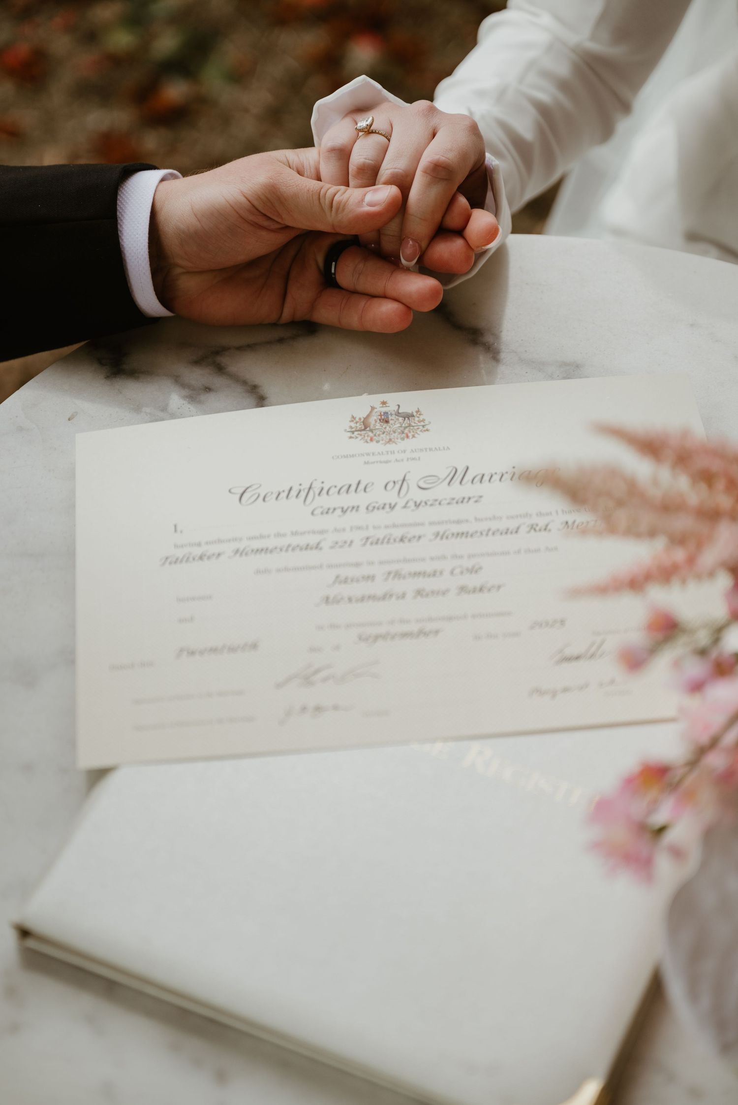 Close-up shots of hands signing a marriage certificate with elegant calligraphy visible on white paper.
