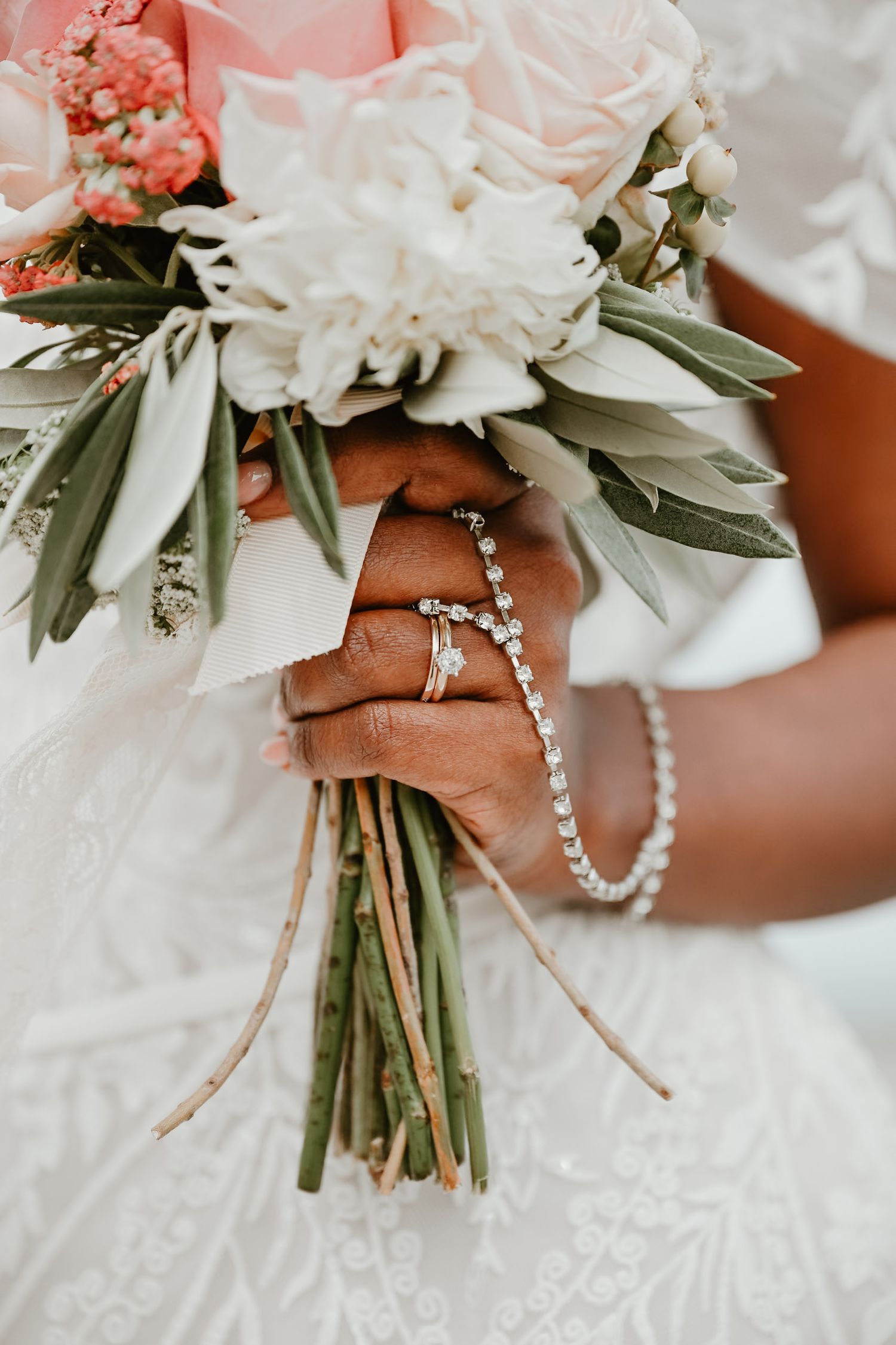 Wedding bouquet with white and pink flowers wrapped in pearl details.