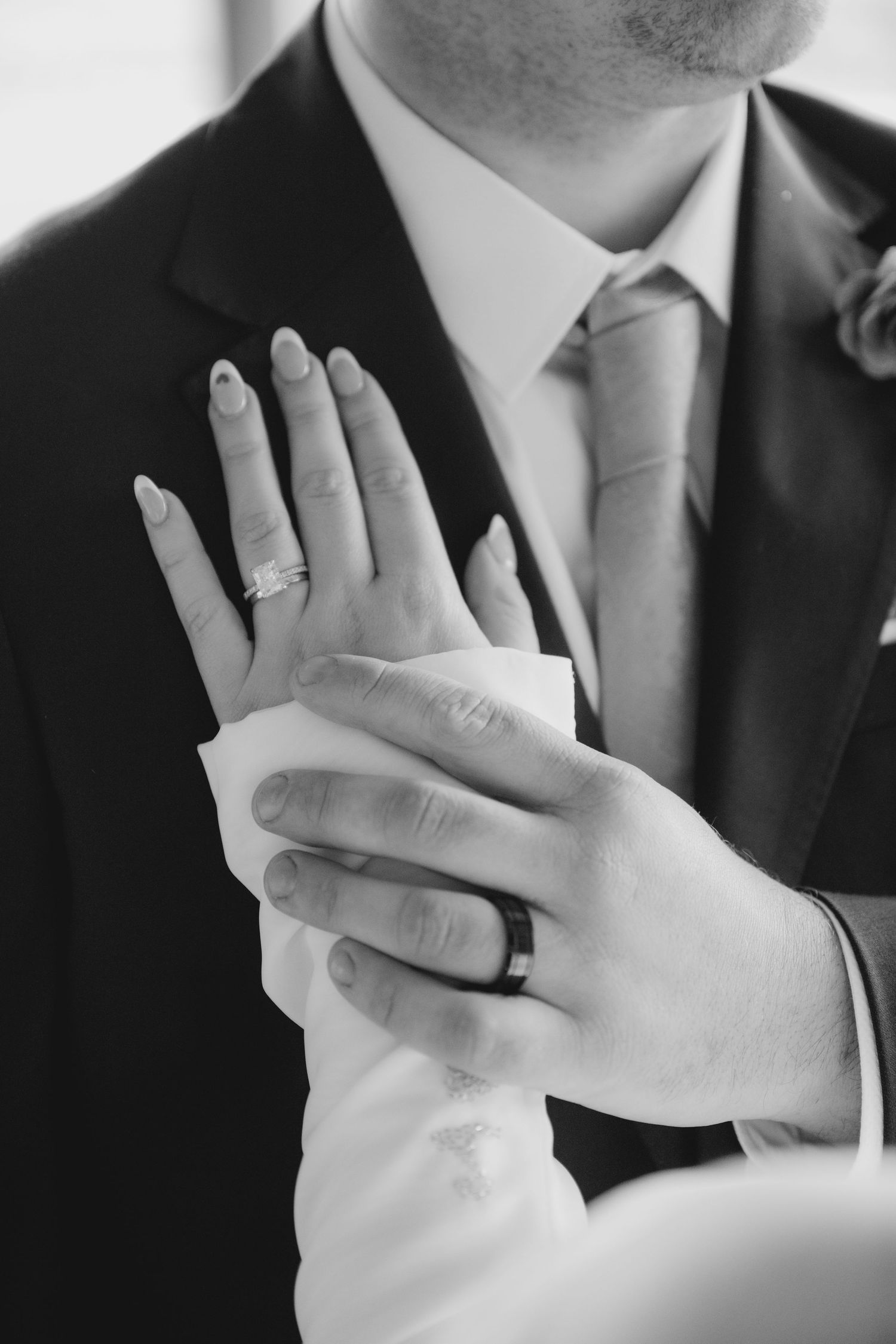 Black and white photo series showing hands wearing wedding rings against formal suit attire.