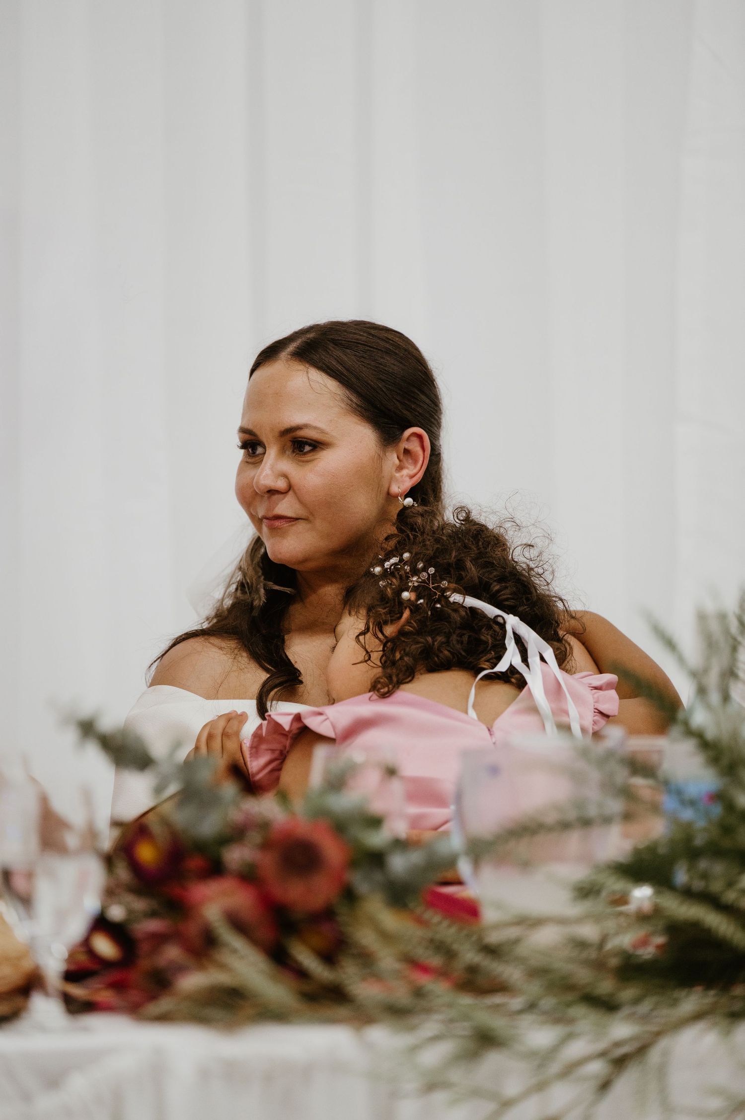 A series of four artistic wedding photos showing a bride with floral arrangements in warm burgundy and pink tones.