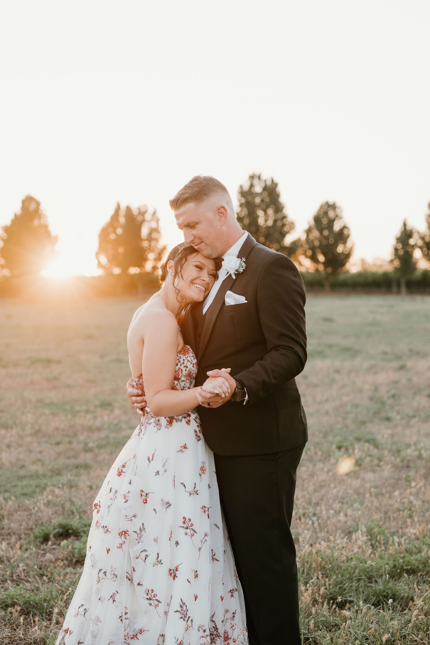 A sunset wedding portrait captures a romantic moment in golden hour light.