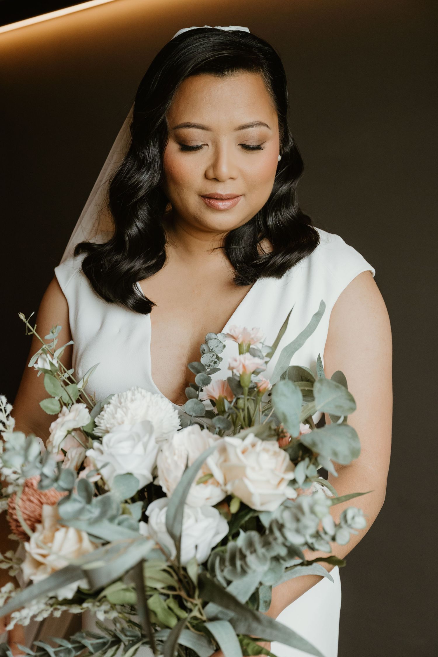 Elegant bridal portrait series showing a bouquet of white flowers and eucalyptus against a dark background.