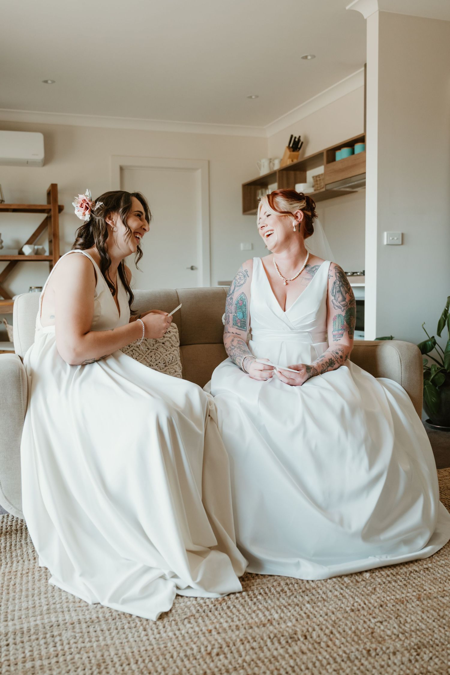 Wedding morning scene with people in white dresses sitting on carpet.