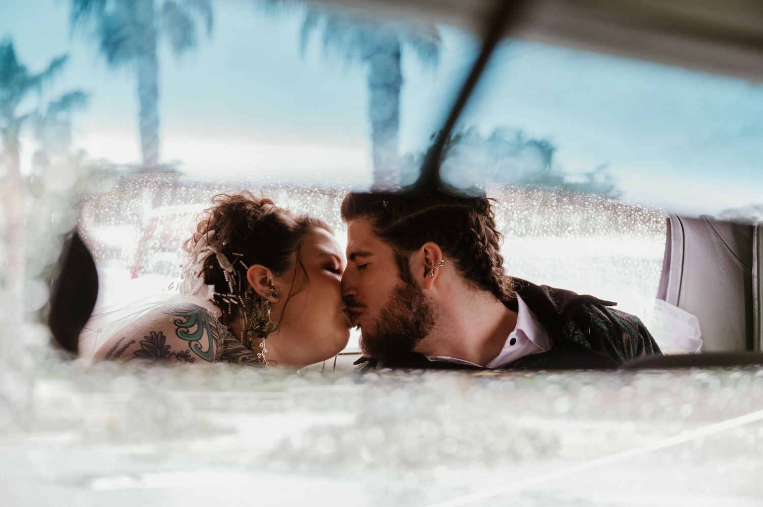 A series of romantic beach photos showing a couple lying in the sand with waves washing over them.