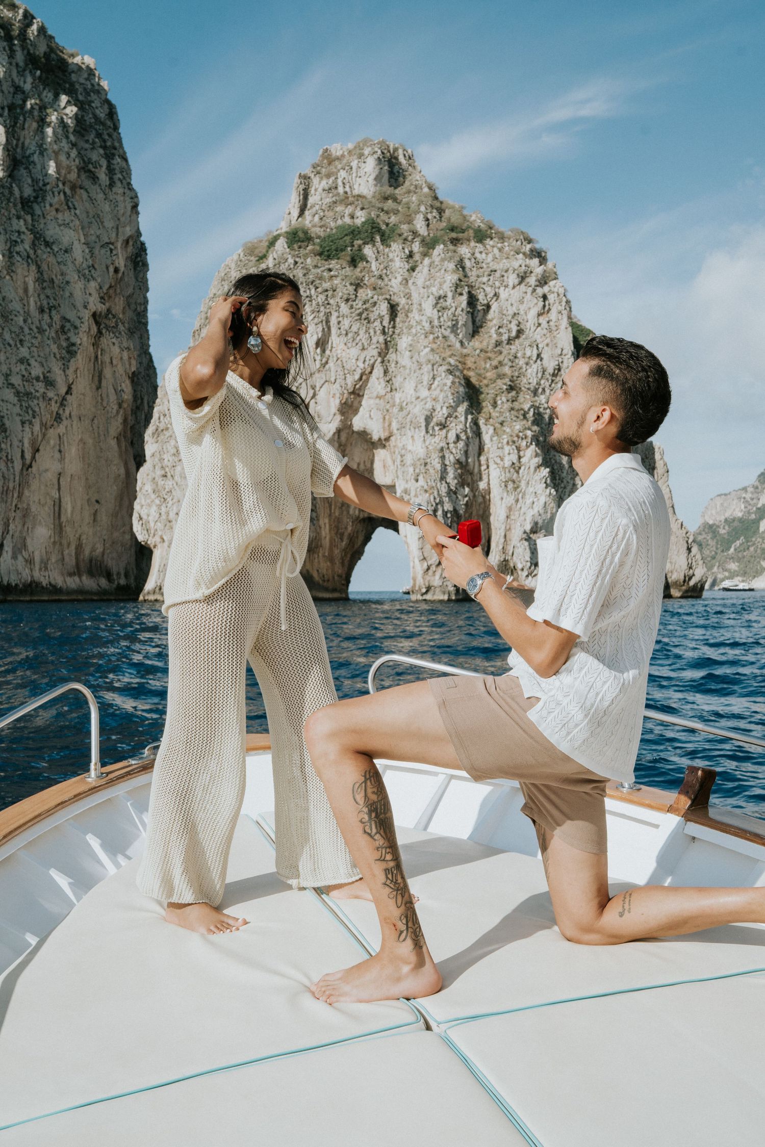 A playful engagement photoshoot on a boat near Capri's iconic Faraglioni rocks.