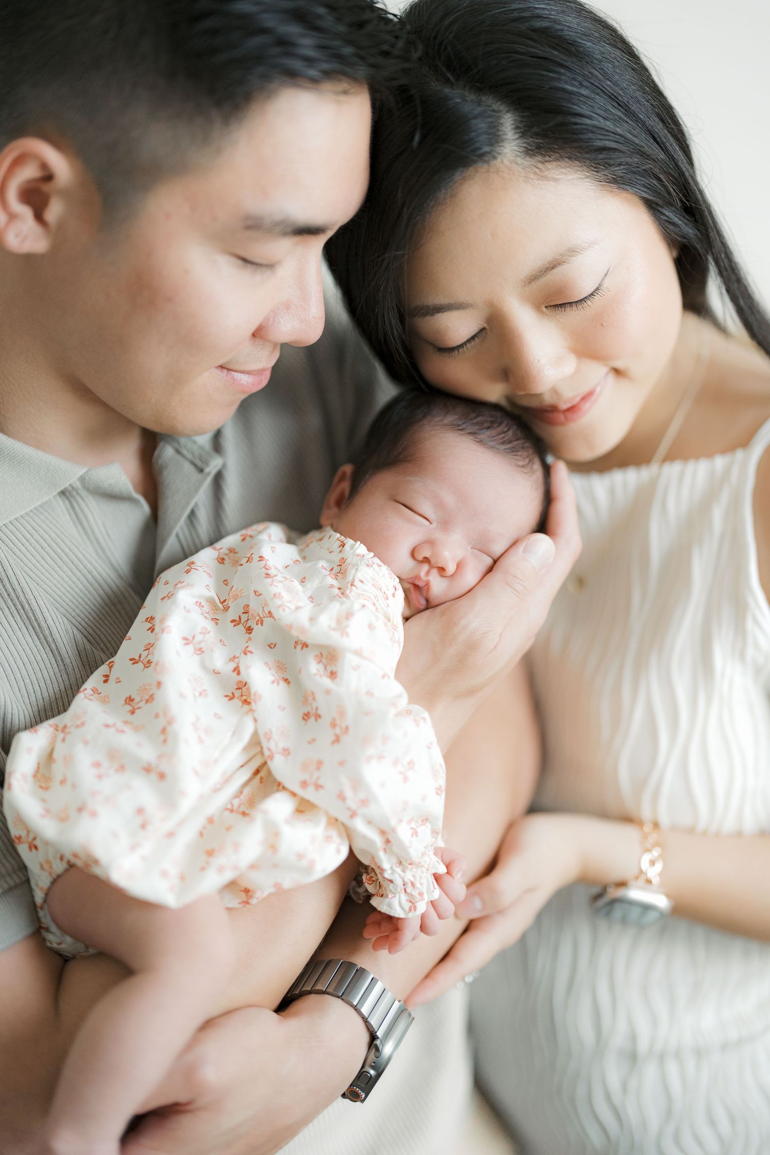 A tender moment captured in a series of intimate family portraits showing parents with their newborn baby.