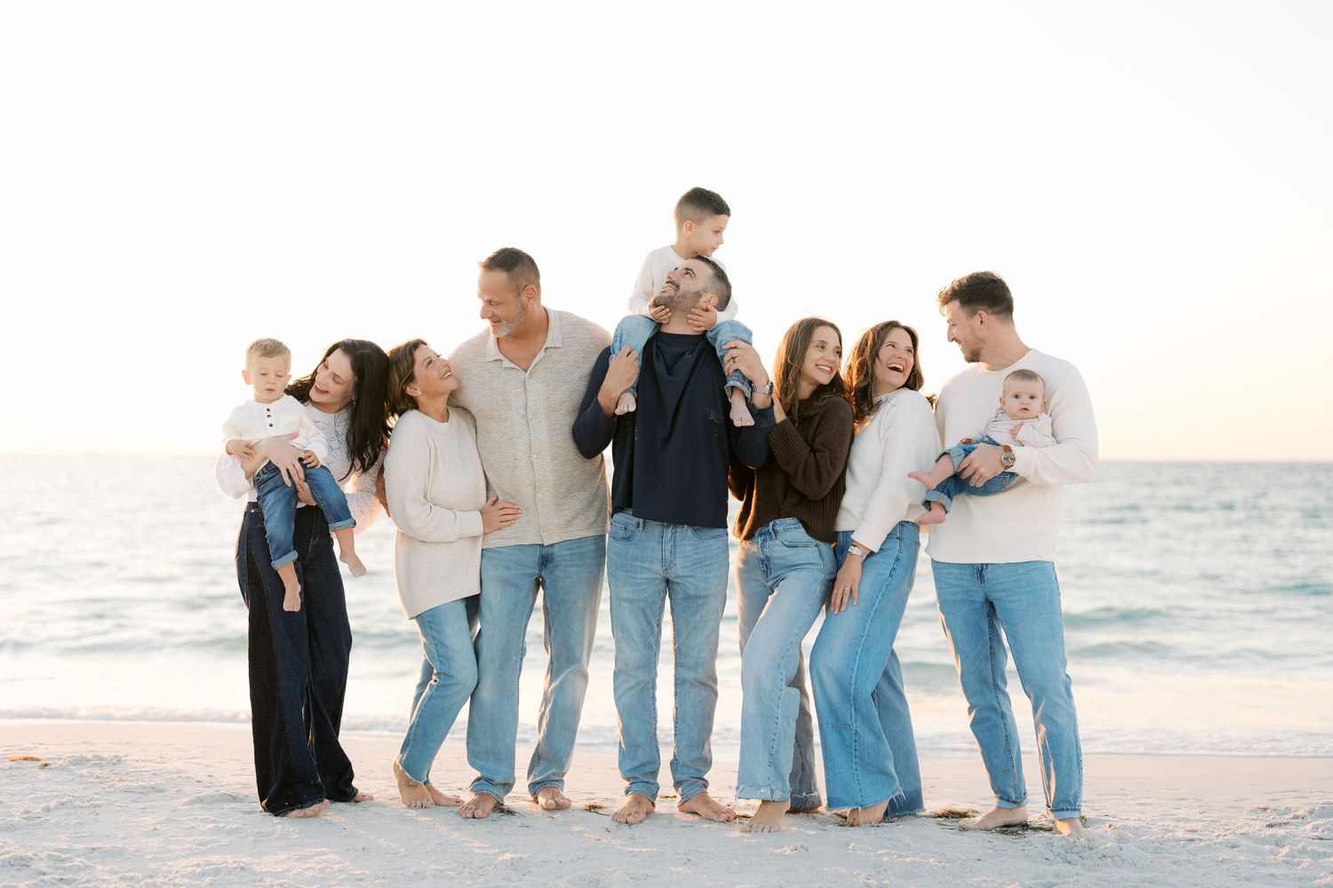 A series of candid beach photos showing a group in coordinated blue and white outfits posing along the shoreline at sunset.