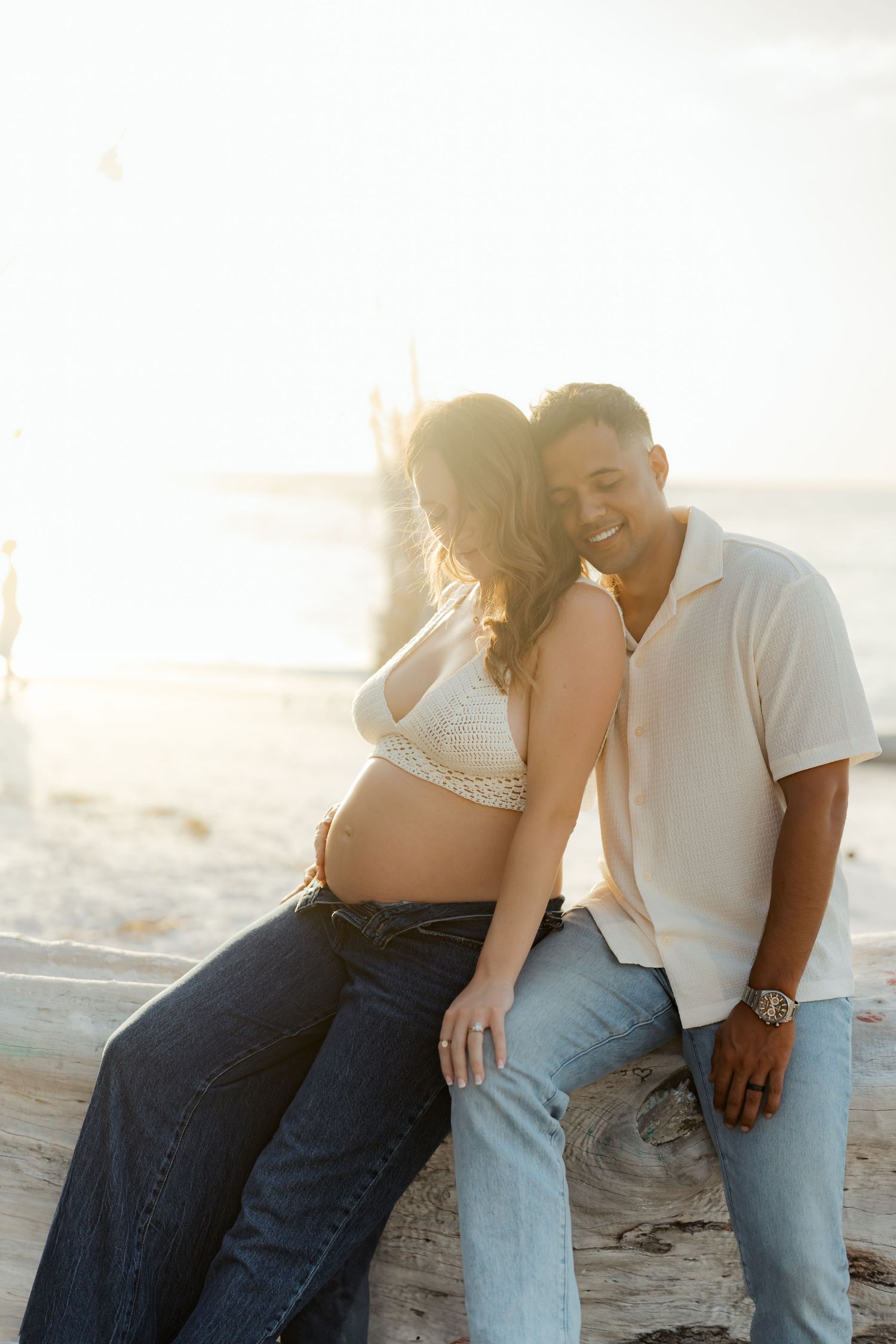 Sunset beach maternity photo of couple sharing intimate moment.