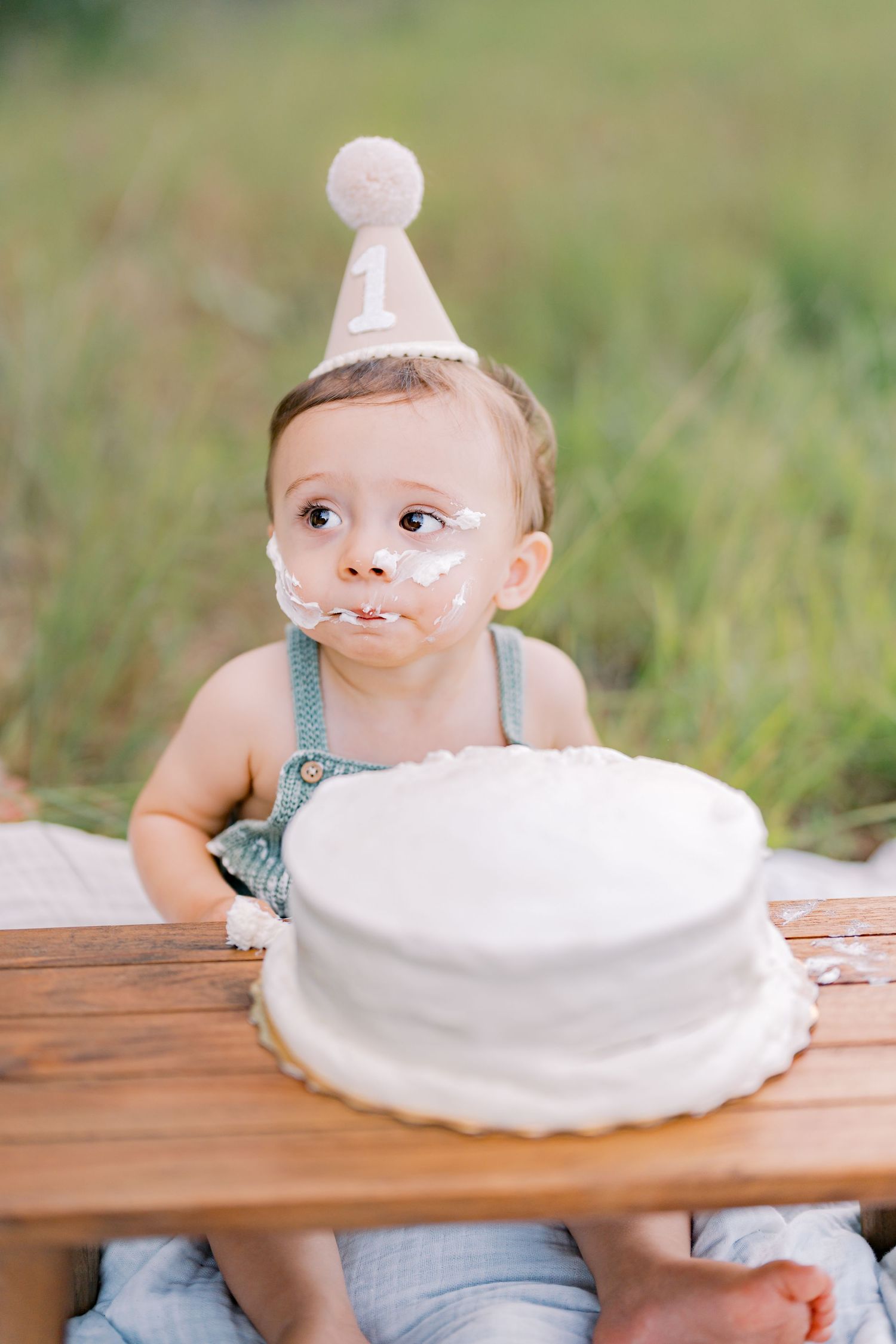 A series of playful photos showing a baby peeking behind a white pie plate on a wooden table outdoors.