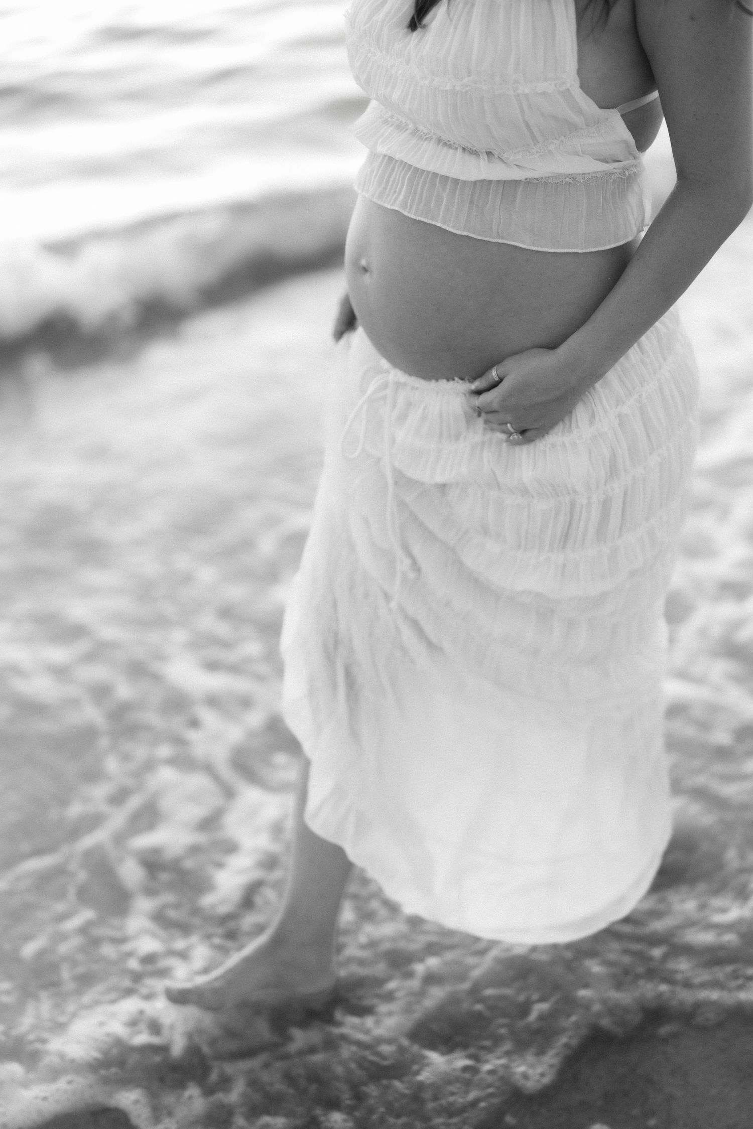 Black and white photo series showing flowing white dress fabric moving in water creating ethereal rippling effects.