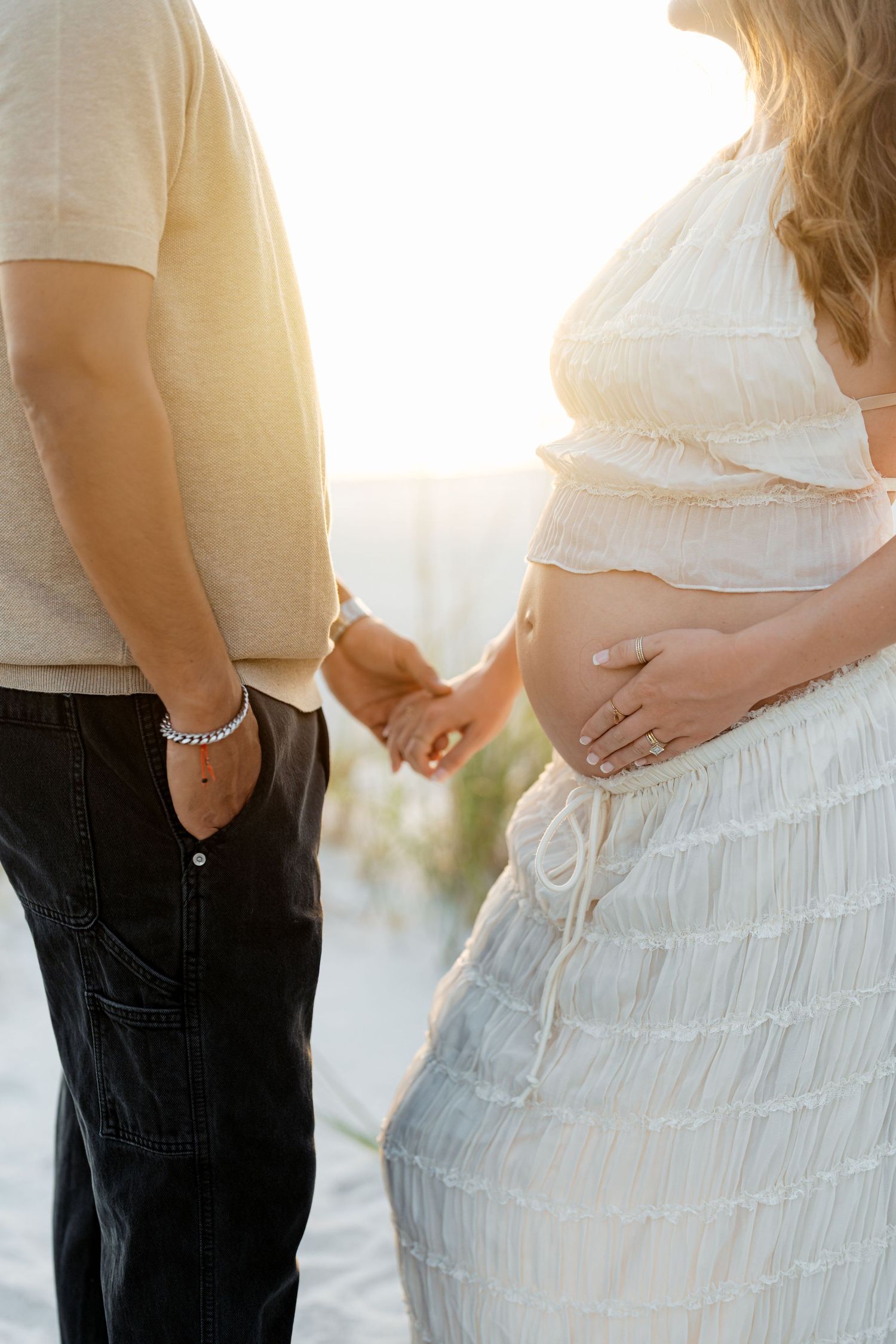 A close-up photo sequence of a pregnant belly shows progression of a woman in white top and dark pants touching her stomach.