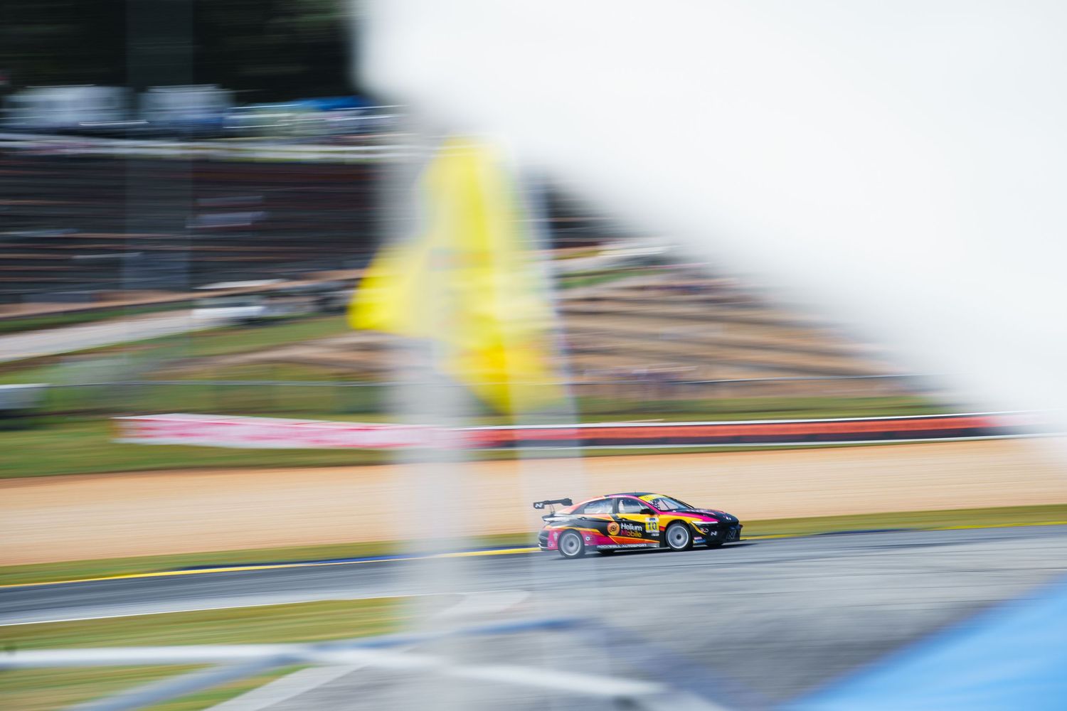 Race car speeds through a track with motion blur creating a dynamic sense of movement and speed.