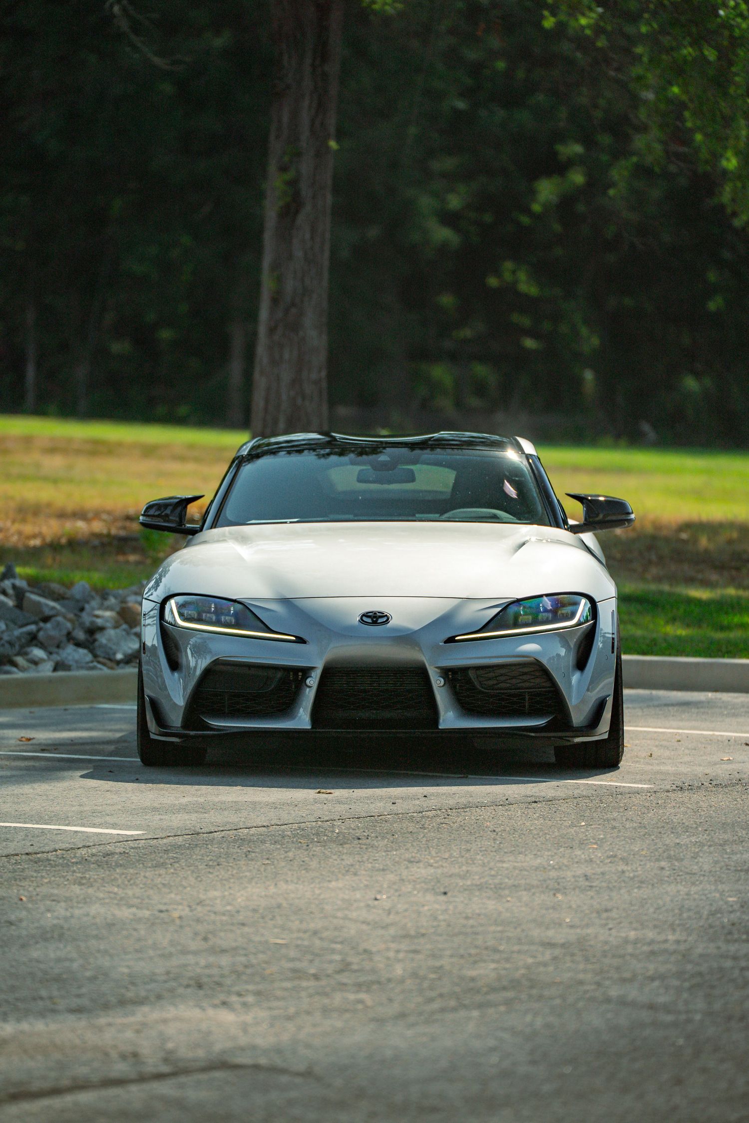 Low angle view of a silver Toyota Supra sports car front end with aggressive styling and LED headlights.