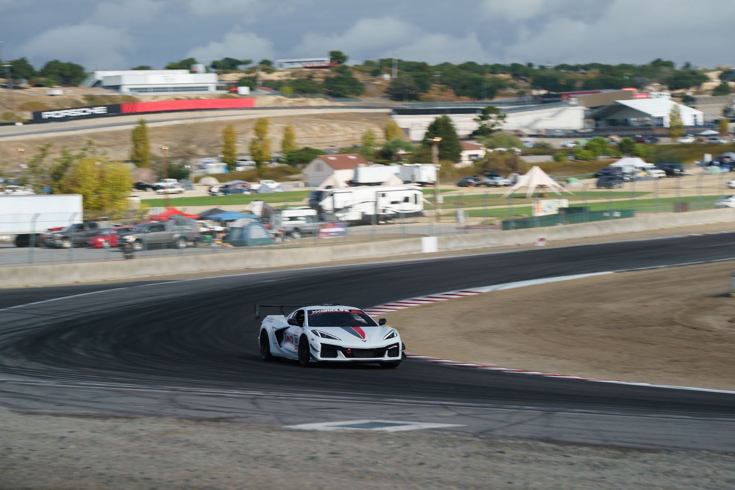 Race cars navigate a challenging turn on a professional racing circuit during a competitive motorsport event.