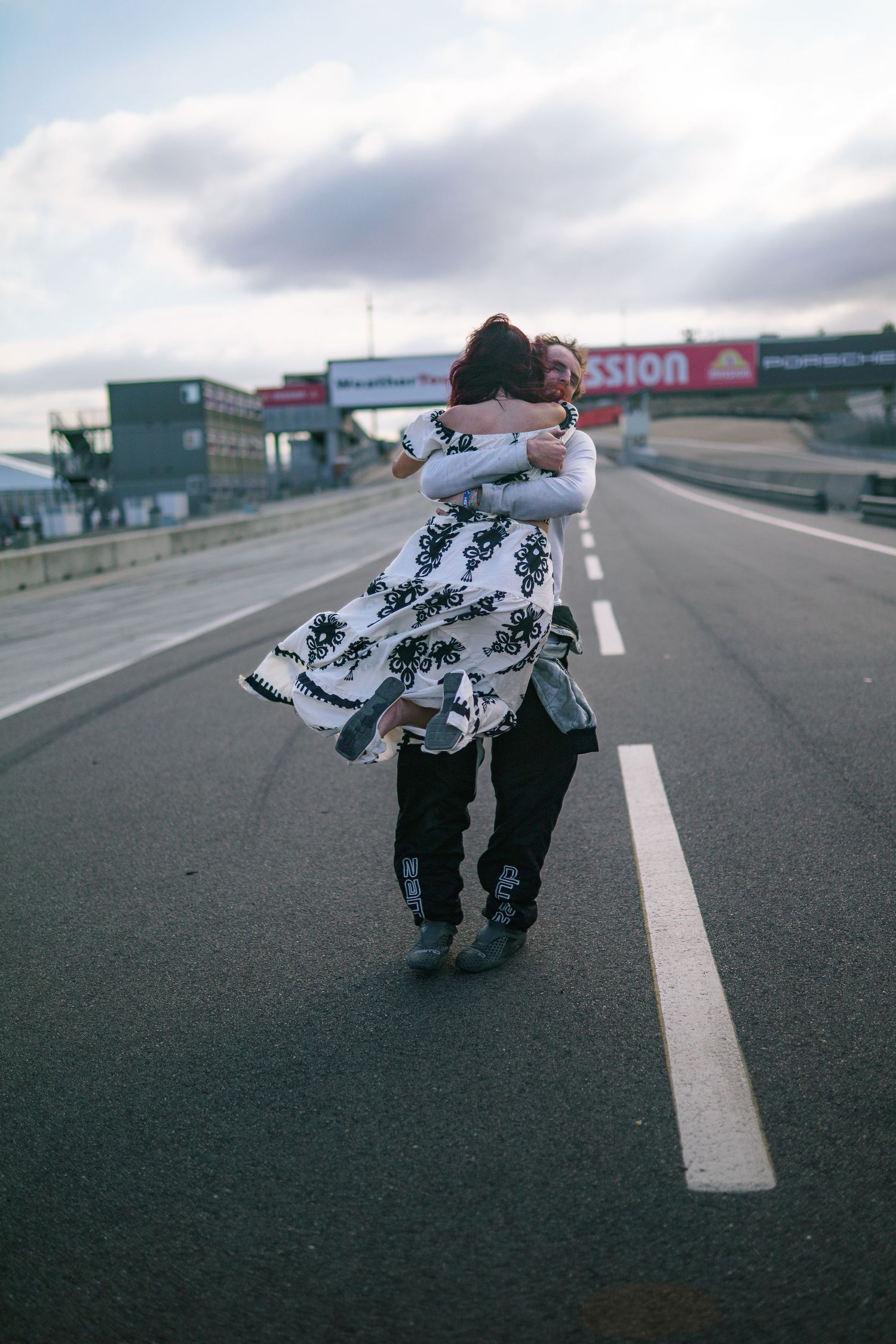 A series of dynamic poses on an empty road showing movement in a flowing black and white patterned garment.