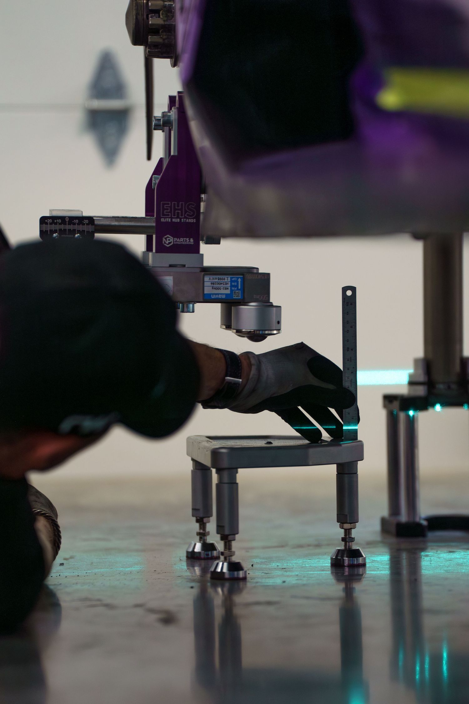 Close-up view of precision measurement or calibration equipment with blue lighting in a controlled environment.