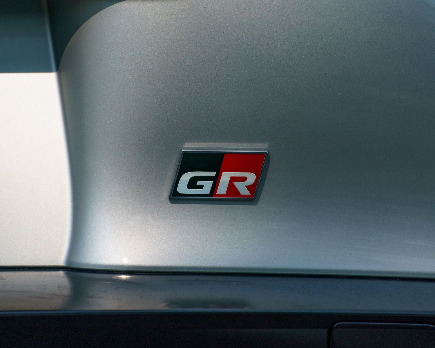 Silver Toyota GR badge detail on a performance vehicle's exterior panel.