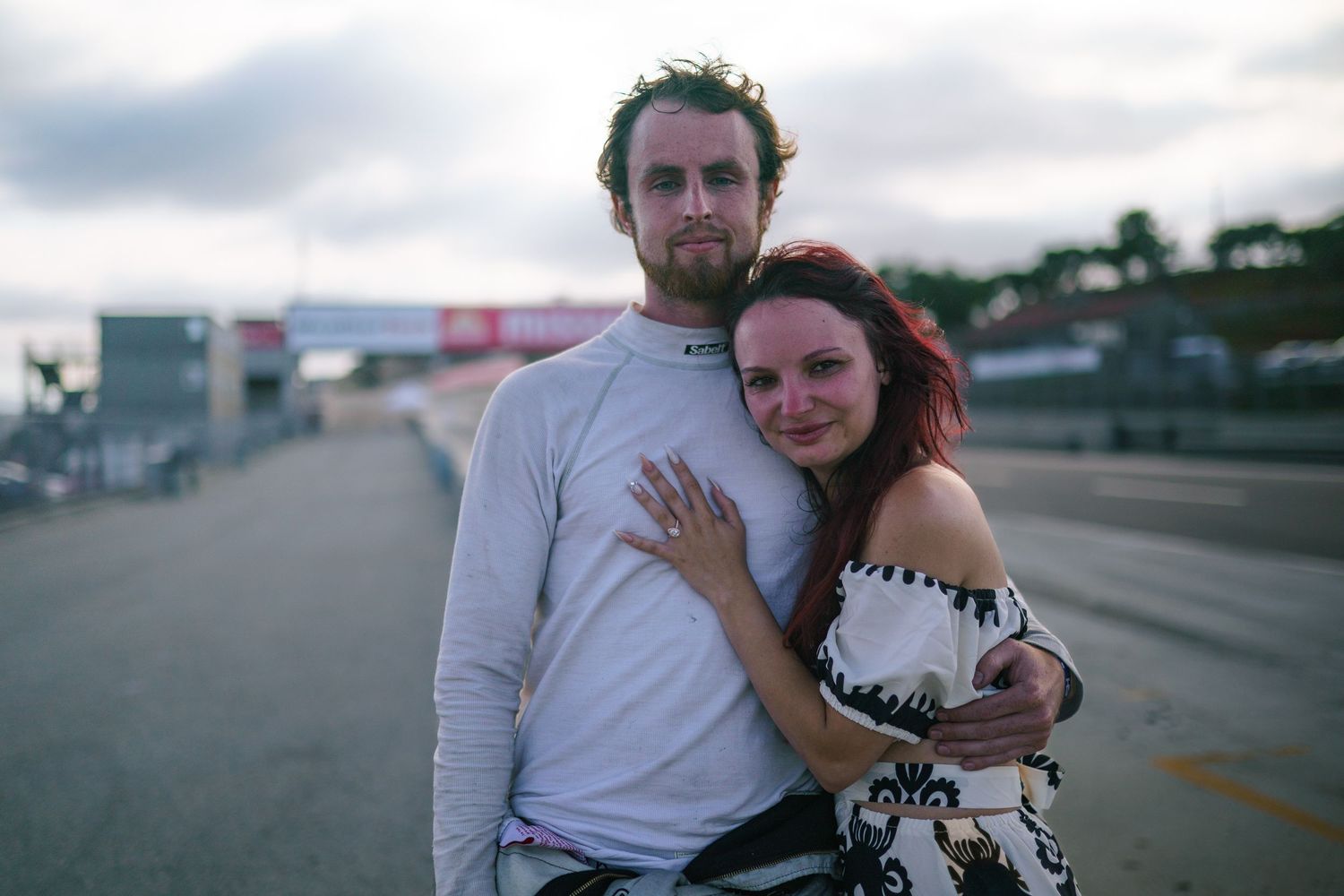 A sequence of romantic moments between a couple embracing on a cloudy day in an outdoor setting.