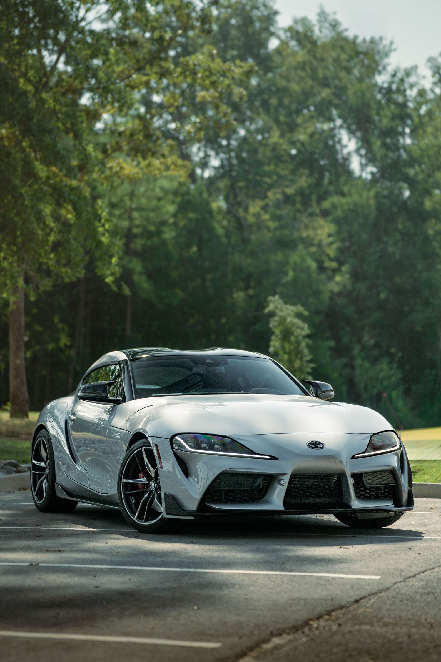 Multiple views of a silver Toyota Supra MK5 sports car parked outdoors with trees in the background.