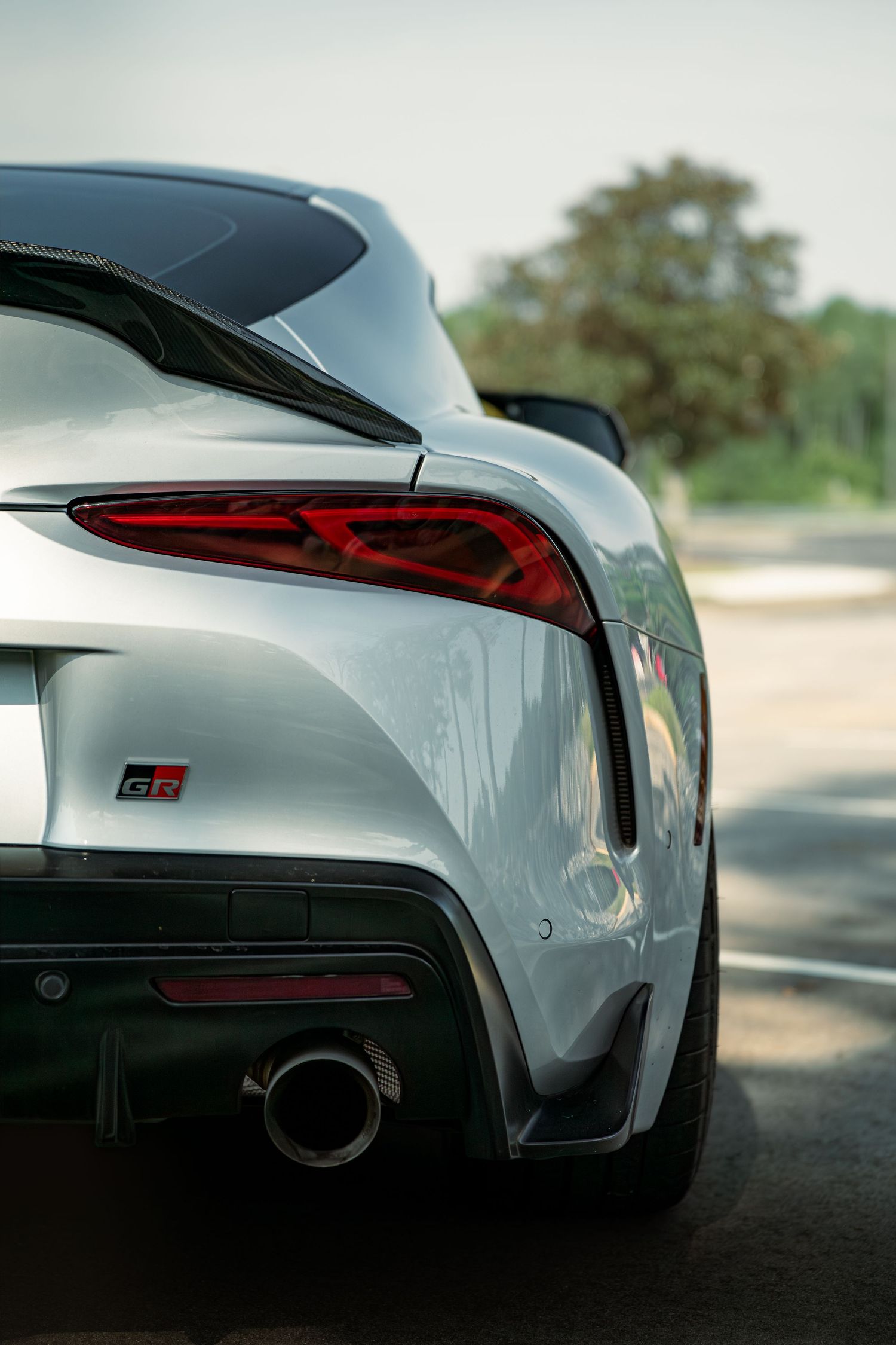 Close-up shots of a silver Toyota GR Supra sports car's rear design elements showing taillights and body panels reveals sleek styling.