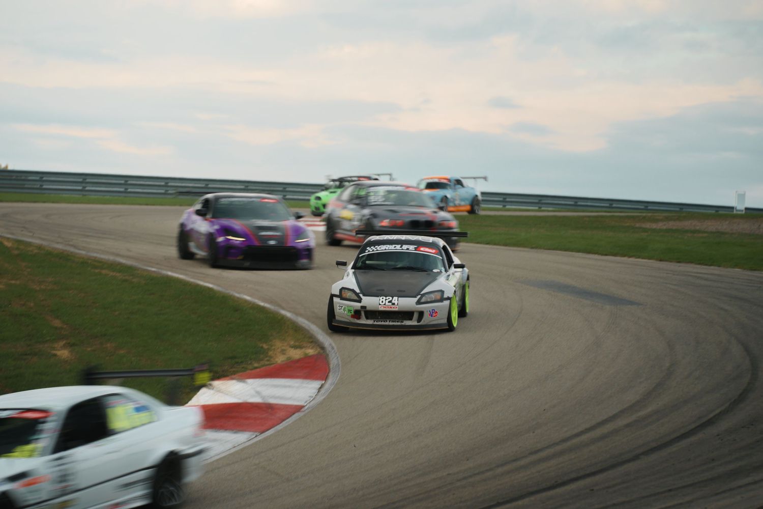 High-performance sports cars racing on a professional track during a competitive motorsport event.