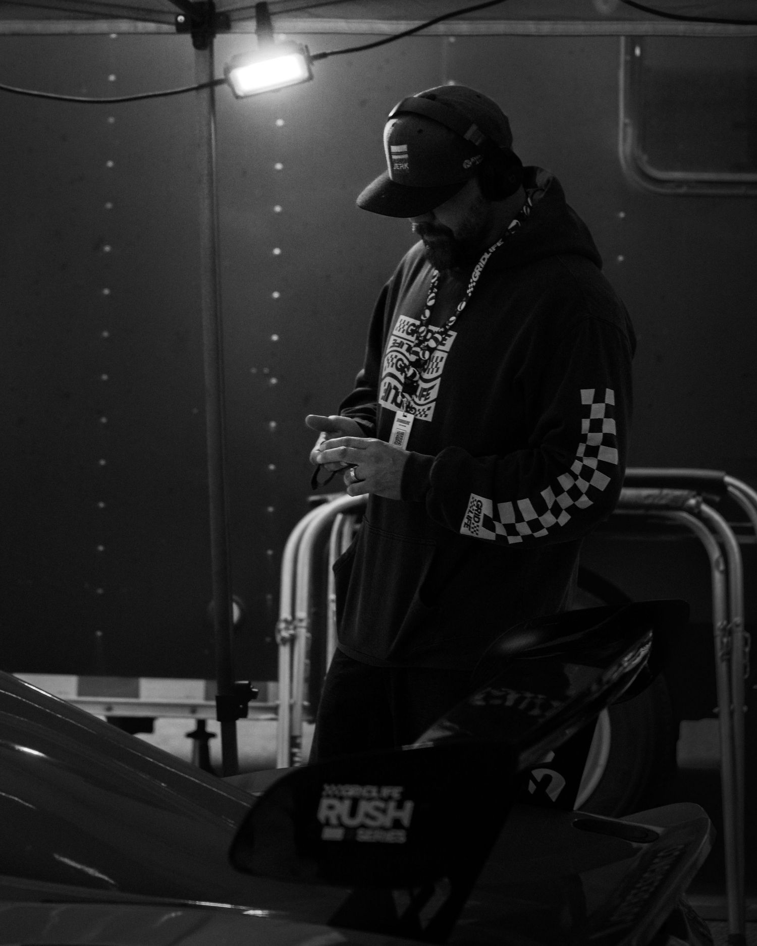 A person sits alone in a dimly lit room with dramatic lighting and shadows creating a moody noir atmosphere.