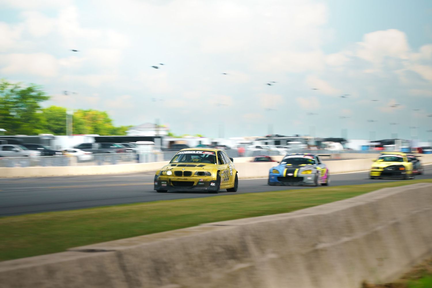 Professional drift cars compete on a racetrack with colorful smoke trails during an intense motorsport competition.