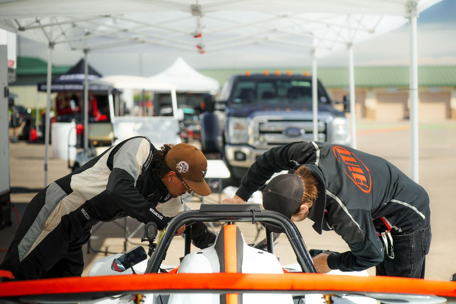 Professional automotive technicians working on vehicle repairs and maintenance in a modern auto service center.