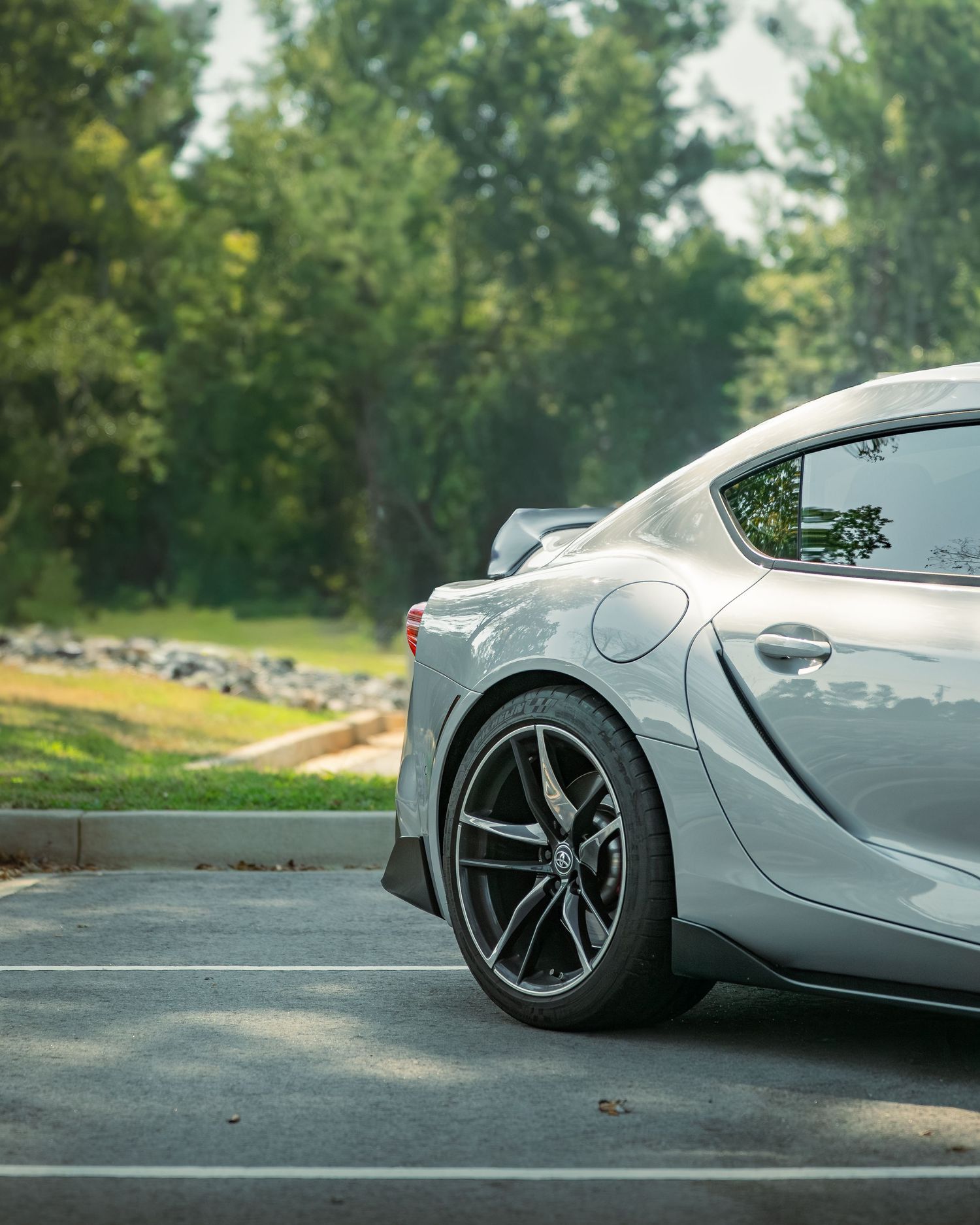 Close-up shots of a luxury car's gray alloy wheels and side panels showing sleek modern automotive design details.