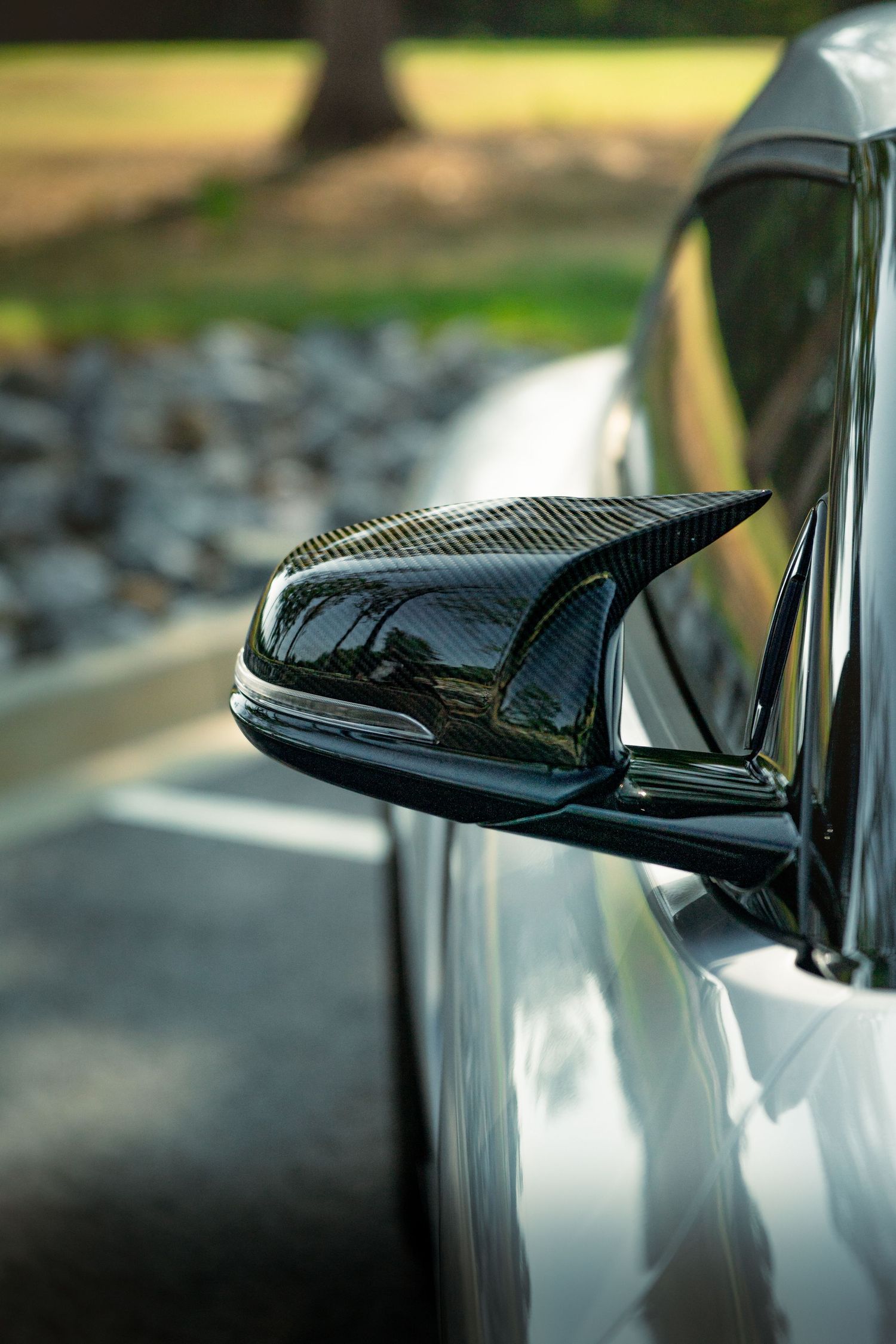 Side mirror detail of a silver Toyota Supra illustrating carbon fiber construction and modern design.