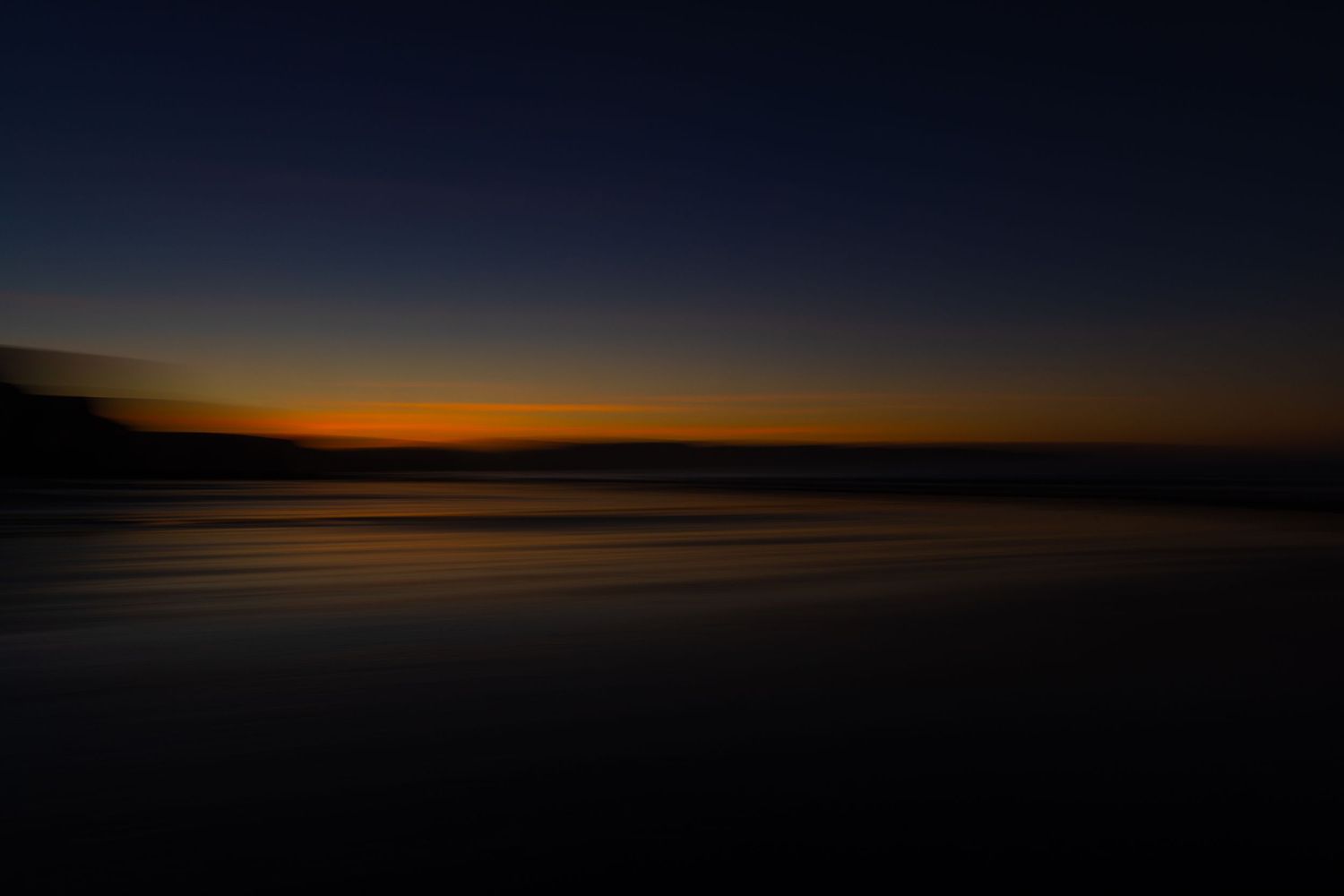 Minimalist dark seascape at twilight with a thin glowing orange strip along the horizon.