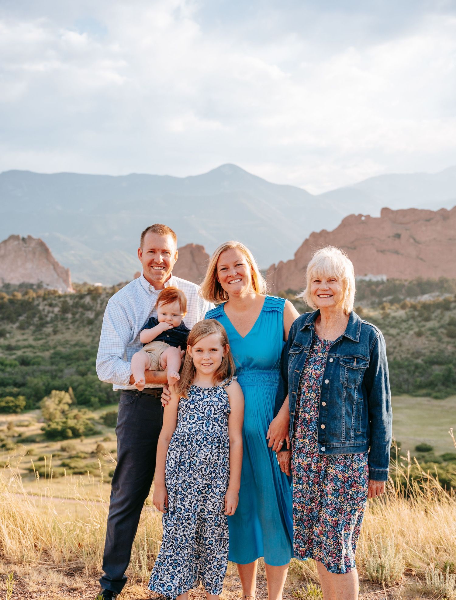 Family of five posing with mountain backdrop at Garden of the Gods.