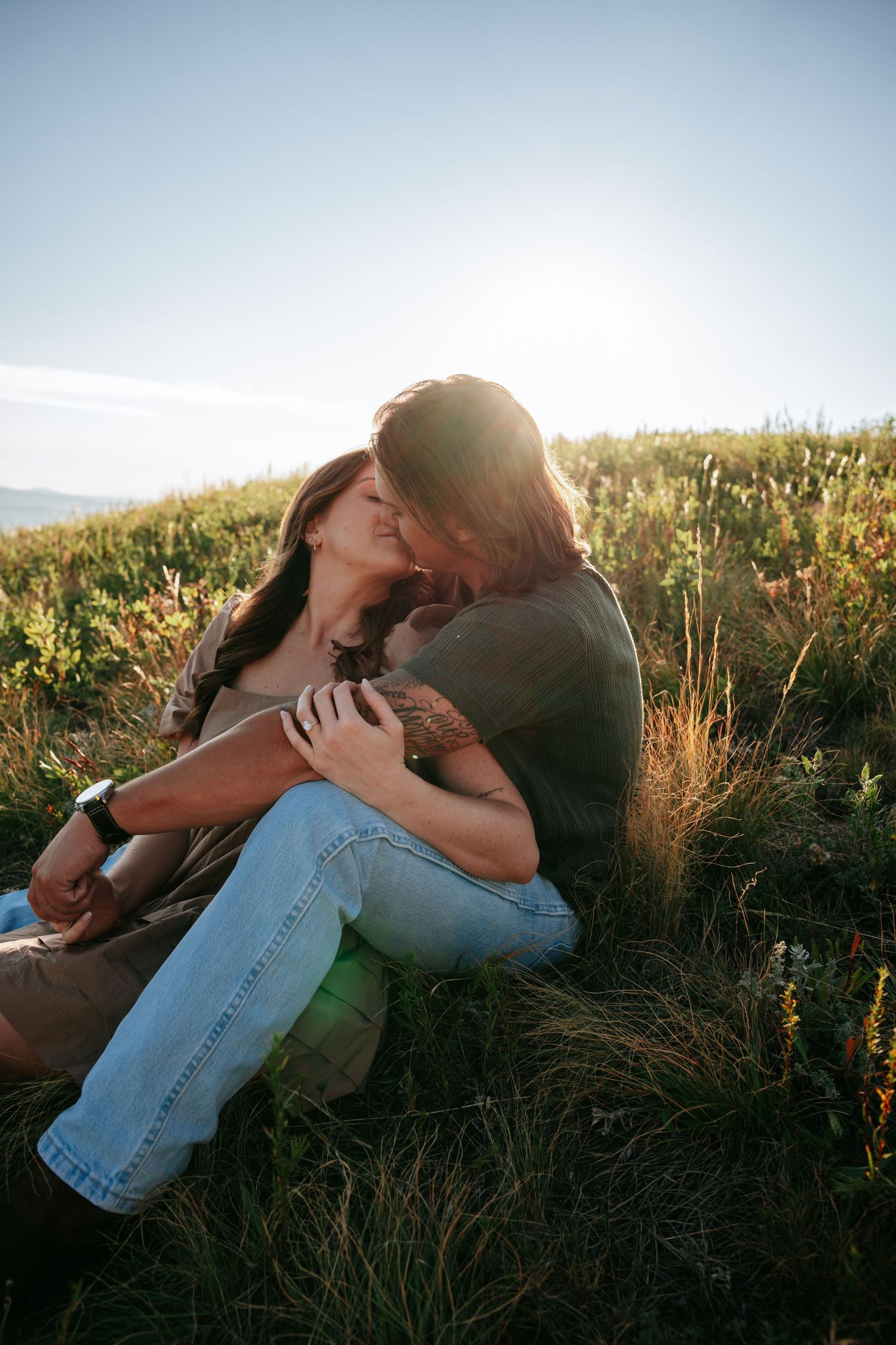 Couple kissing sitting in a meadow