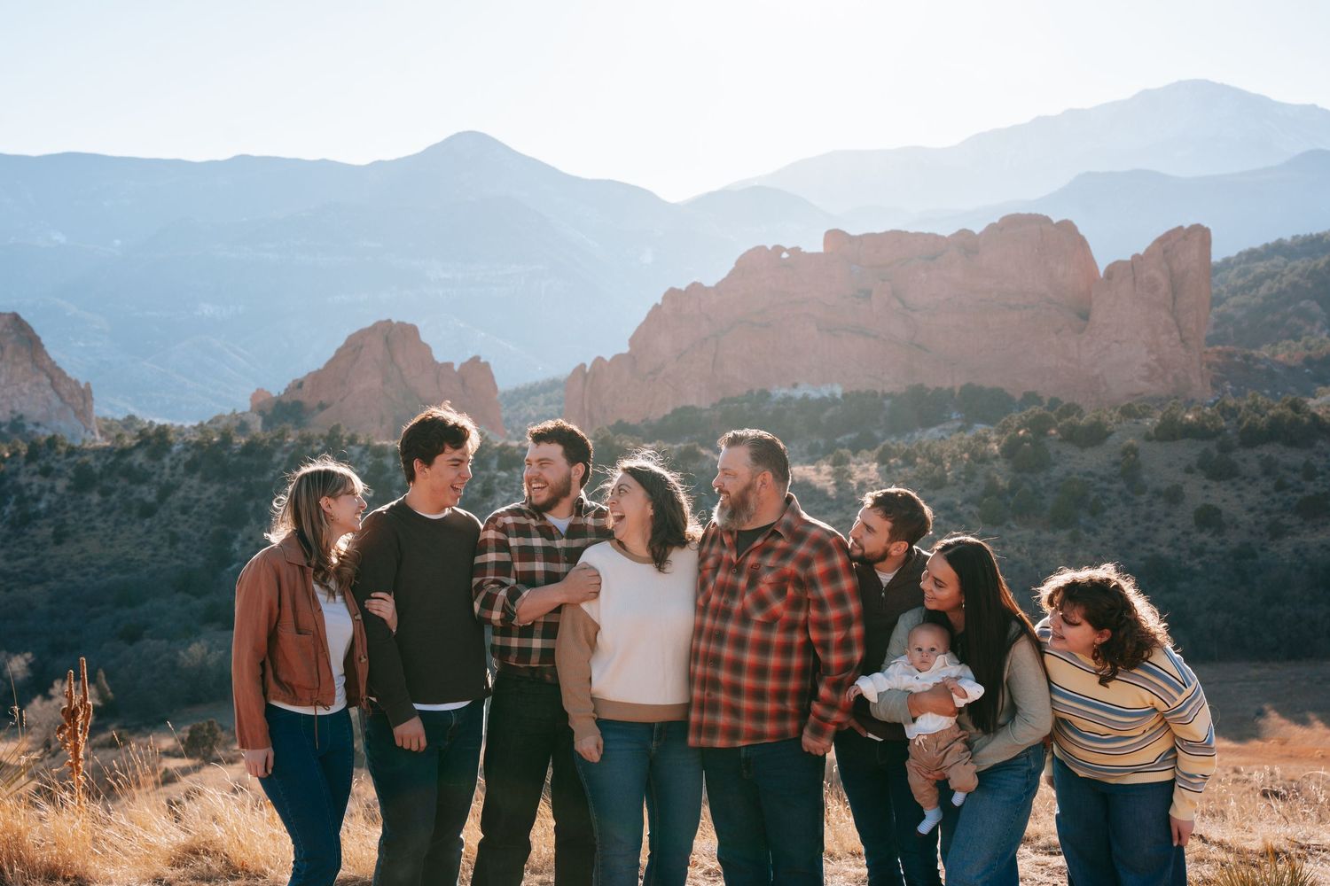 Large family group portrait at Garden of the Gods Colorado with red rock formations and mountains backdrop.