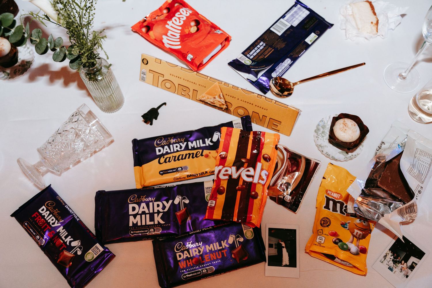 Assorted Cadbury Dairy Milk and other chocolate candy bars spread on a white table.