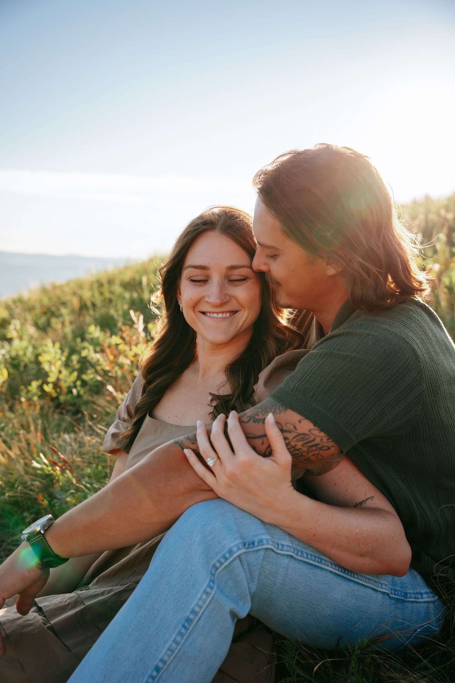 Couple smiling sitting in a meadow